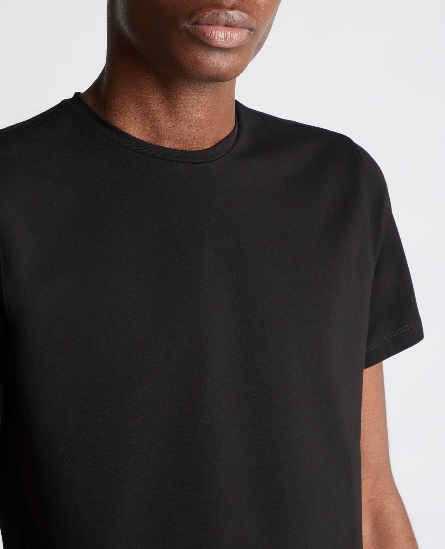 Man wearing a black Tapered Fit Cotton-Stretch T-Shirt