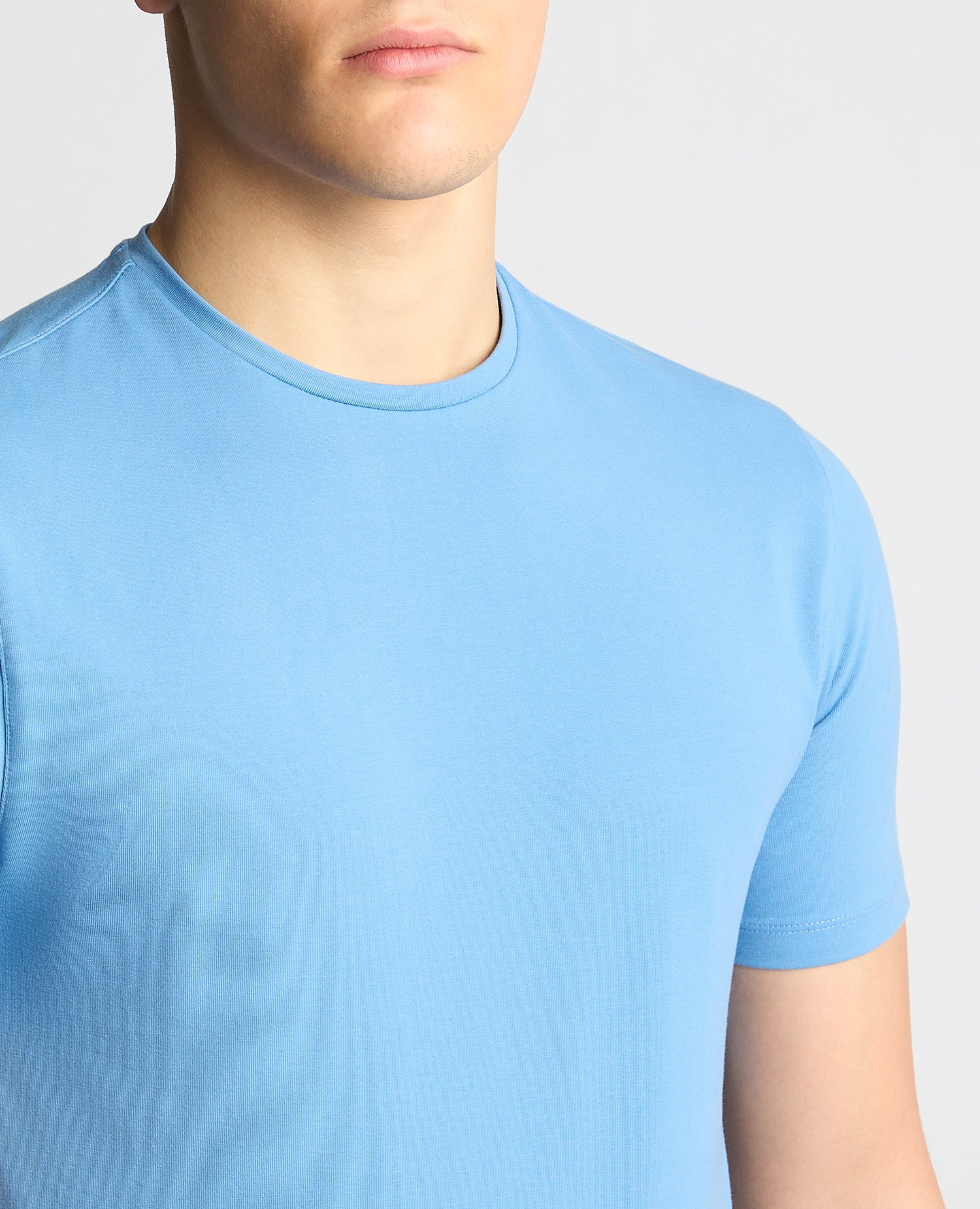 Man wearing a blue Tapered Fit Cotton-Stretch T-Shirt