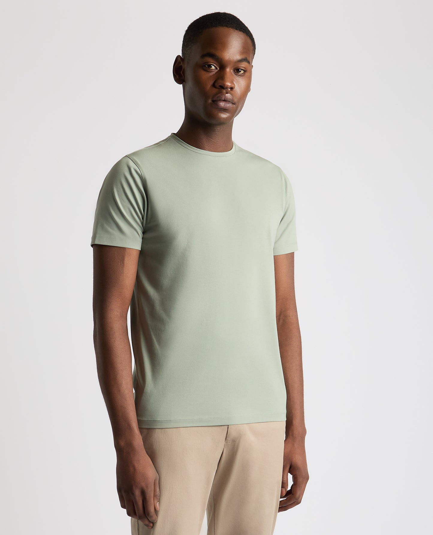 Man wearing a green Tapered Fit Cotton-Stretch T-Shirt