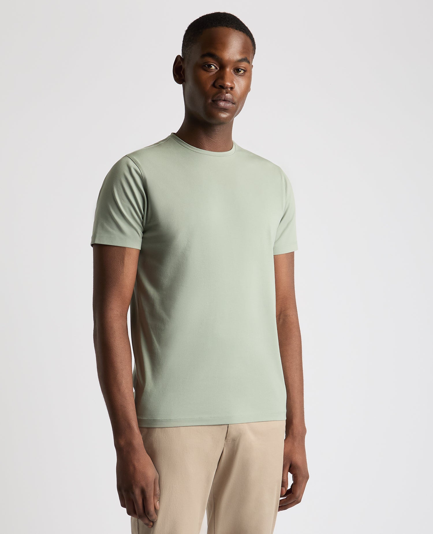 Man wearing a green Tapered Fit Cotton-Stretch T-Shirt