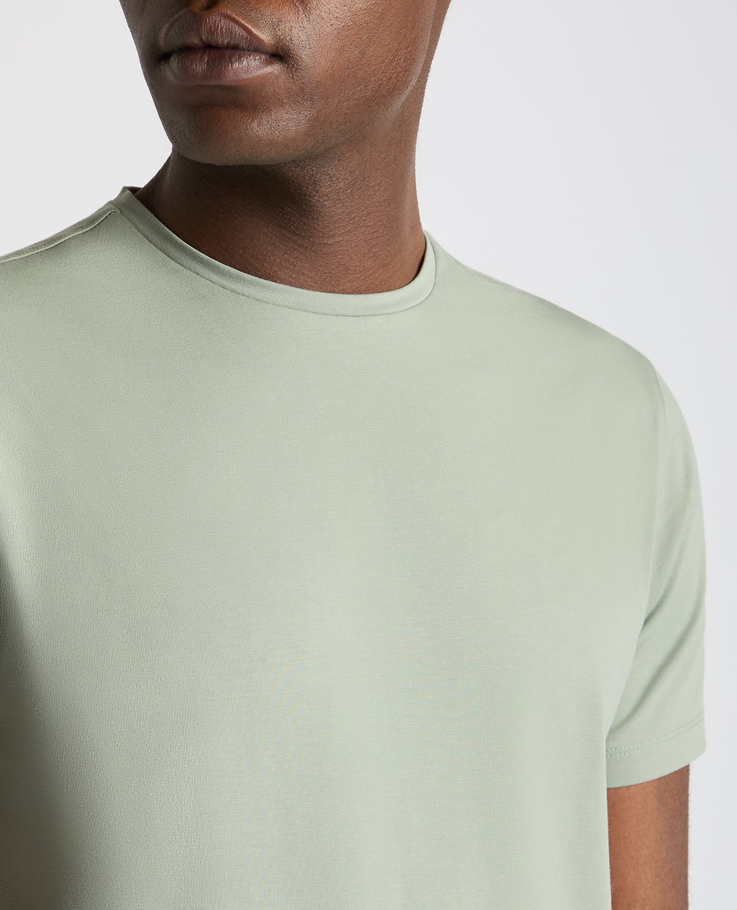 Man wearing a green Tapered Fit Cotton-Stretch T-Shirt
