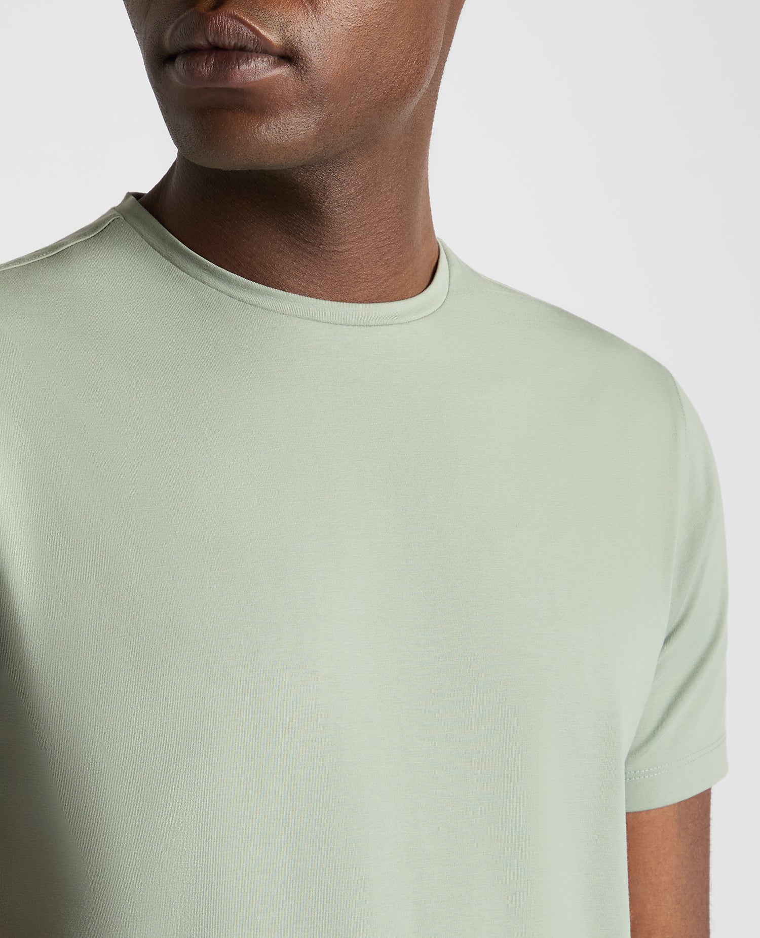 Man wearing a green Tapered Fit Cotton-Stretch T-Shirt