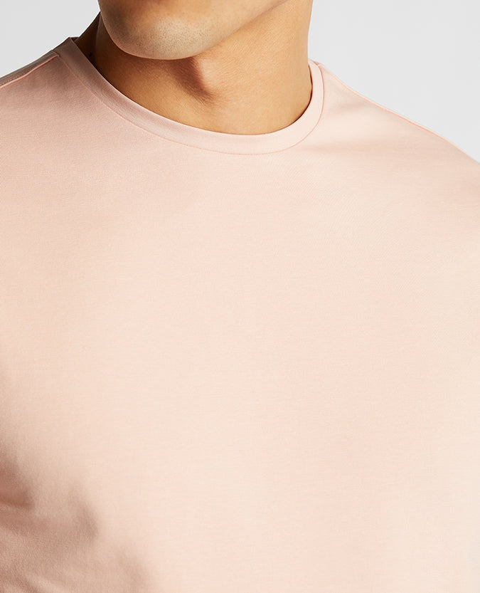 Man wearing a pink Tapered Fit Cotton-Stretch T-Shirt