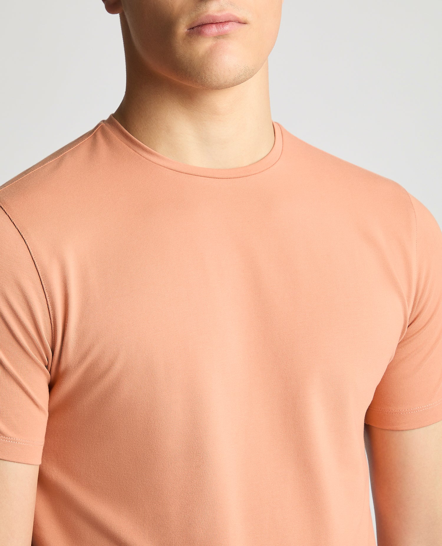 Man wearing a red Tapered Fit Cotton-Stretch T-Shirt