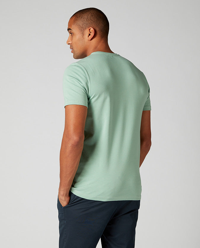 Man wearing a green Tapered Fit Cotton-Stretch T-Shirt