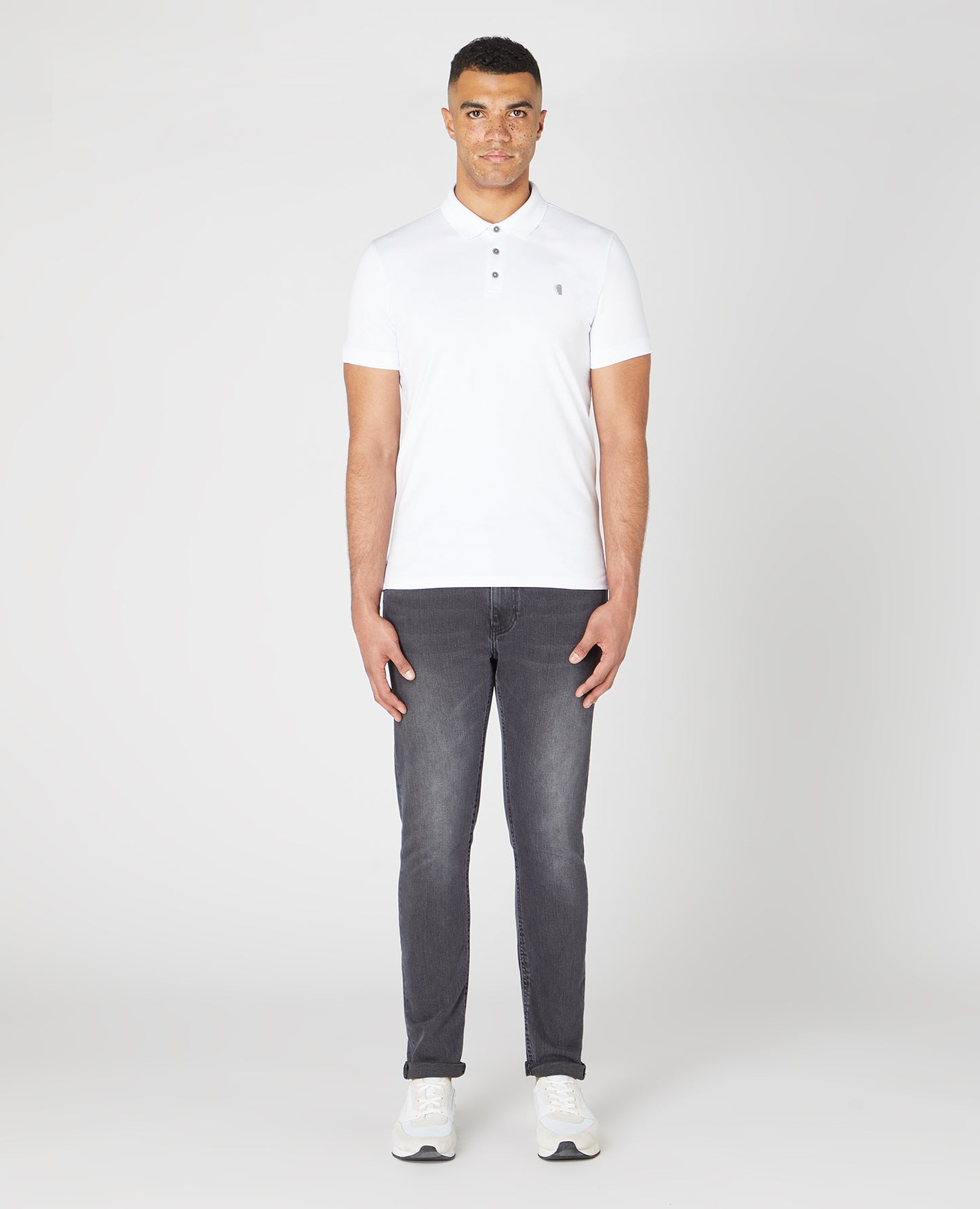 Man wearing a white Tapered Fit Cotton-Stretch Polo Shirt
