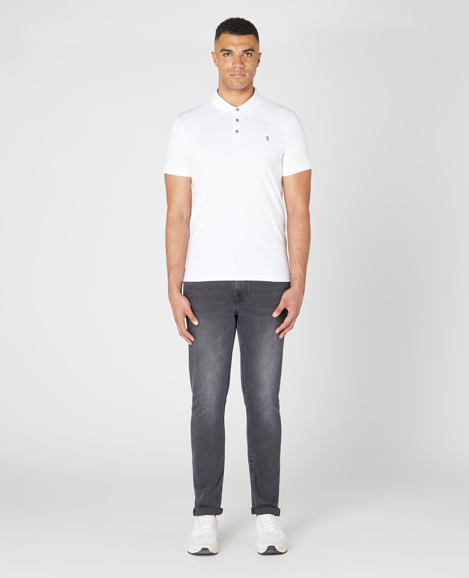 Man wearing a white Tapered Fit Cotton-Stretch Polo Shirt