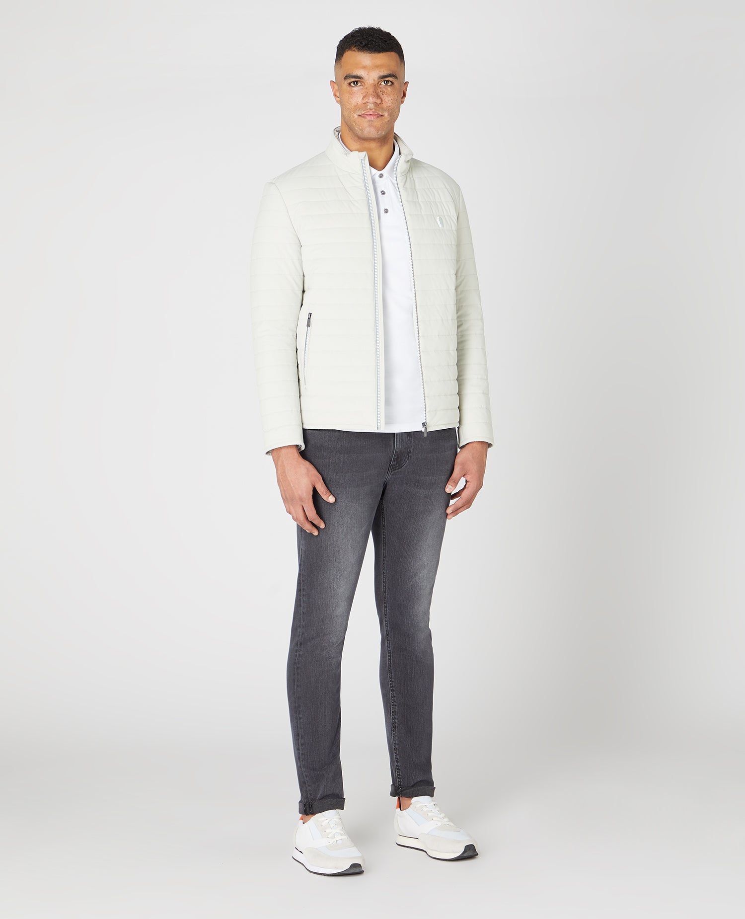 Man wearing a white Tapered Fit Cotton-Stretch Polo Shirt