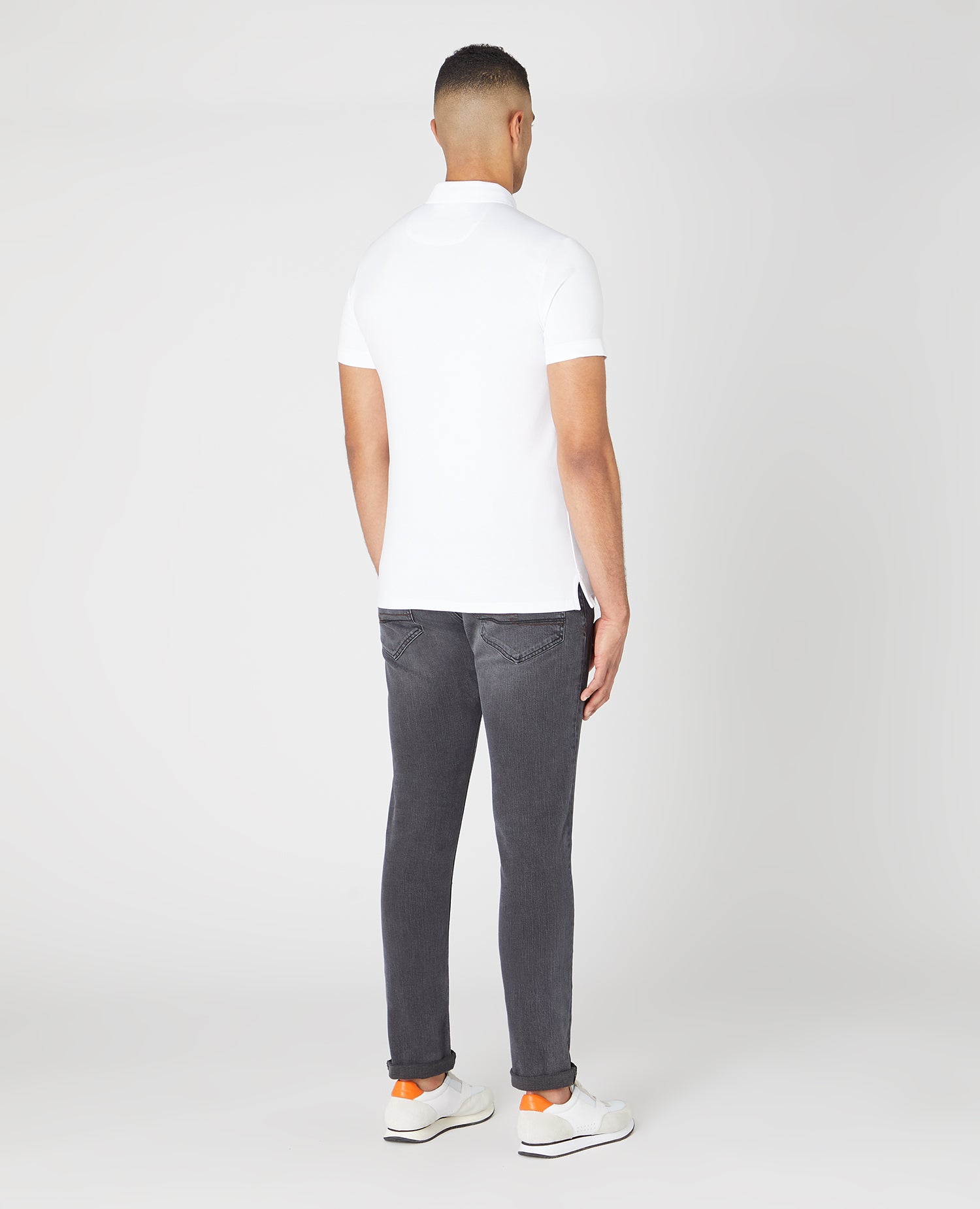 Man wearing a white Tapered Fit Cotton-Stretch Polo Shirt