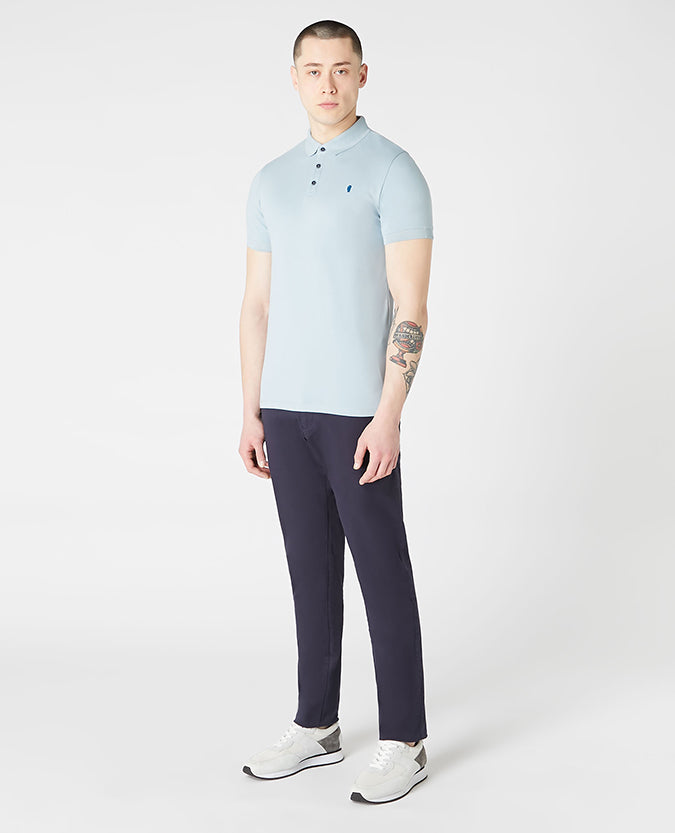 Man wearing a blue Tapered Fit Cotton-Blend Stretch Polo Shirt