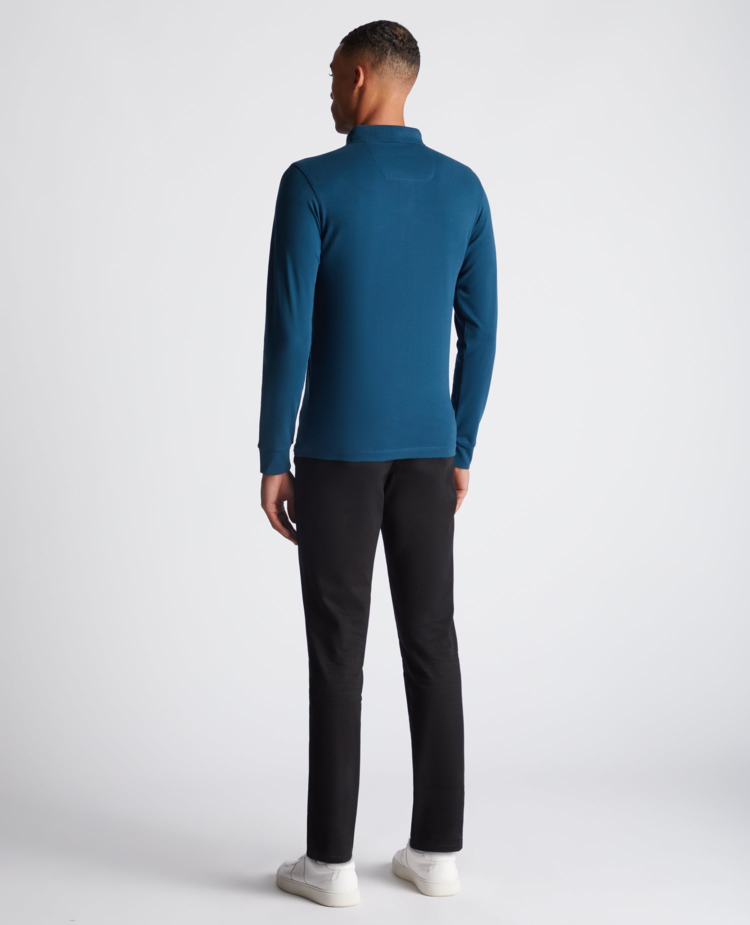Man wearing a blue Tapered Fit Cotton-Stretch Long-Sleeve Polo Shirt