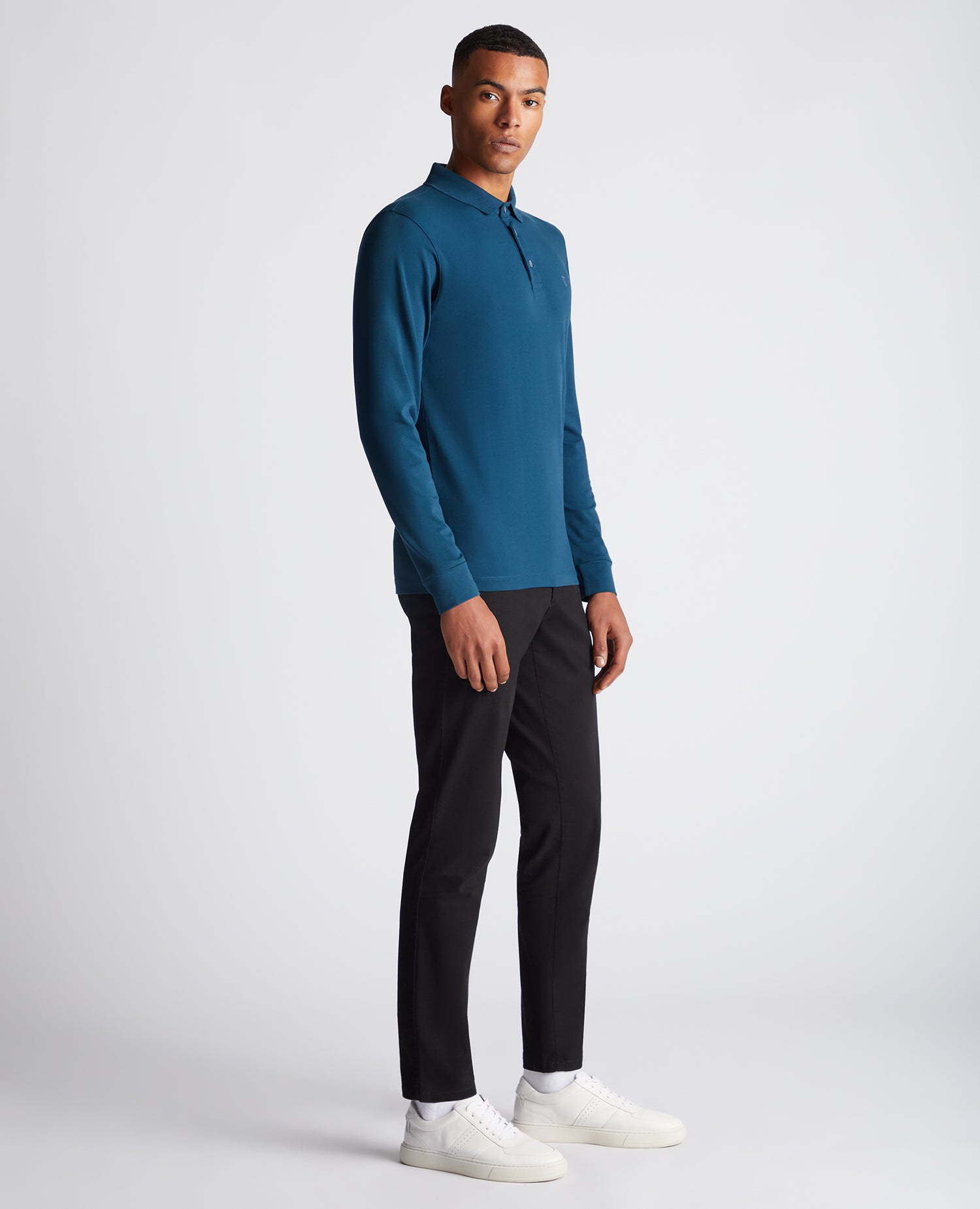 Man wearing a blue Tapered Fit Cotton-Stretch Long-Sleeve Polo Shirt