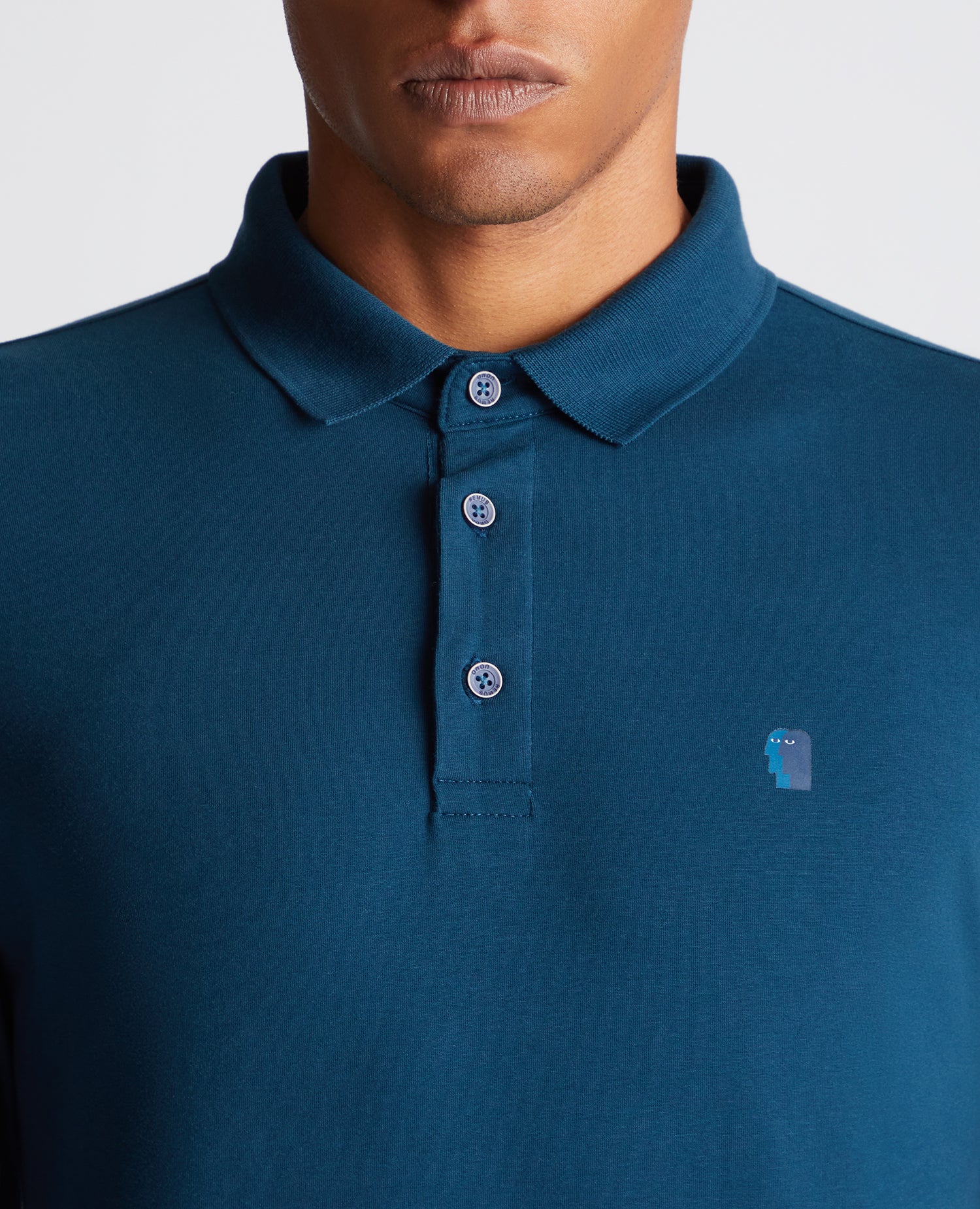 Man wearing a blue Tapered Fit Cotton-Stretch Long-Sleeve Polo Shirt