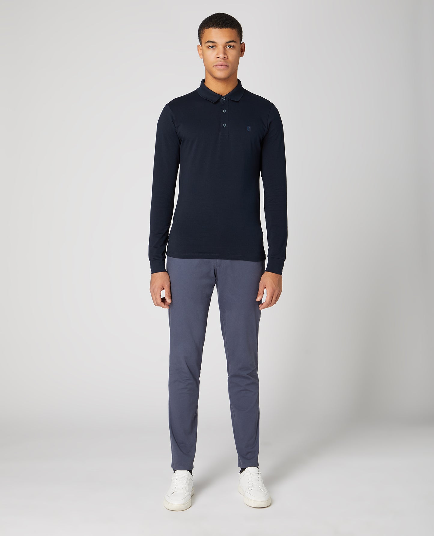 Man wearing a navy Tapered Fit Cotton-Stretch Long-Sleeve Polo Shirt