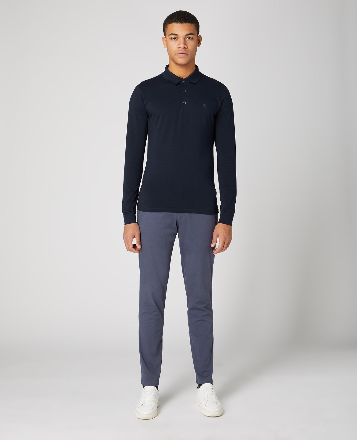 Man wearing a navy Tapered Fit Cotton-Stretch Long-Sleeve Polo Shirt