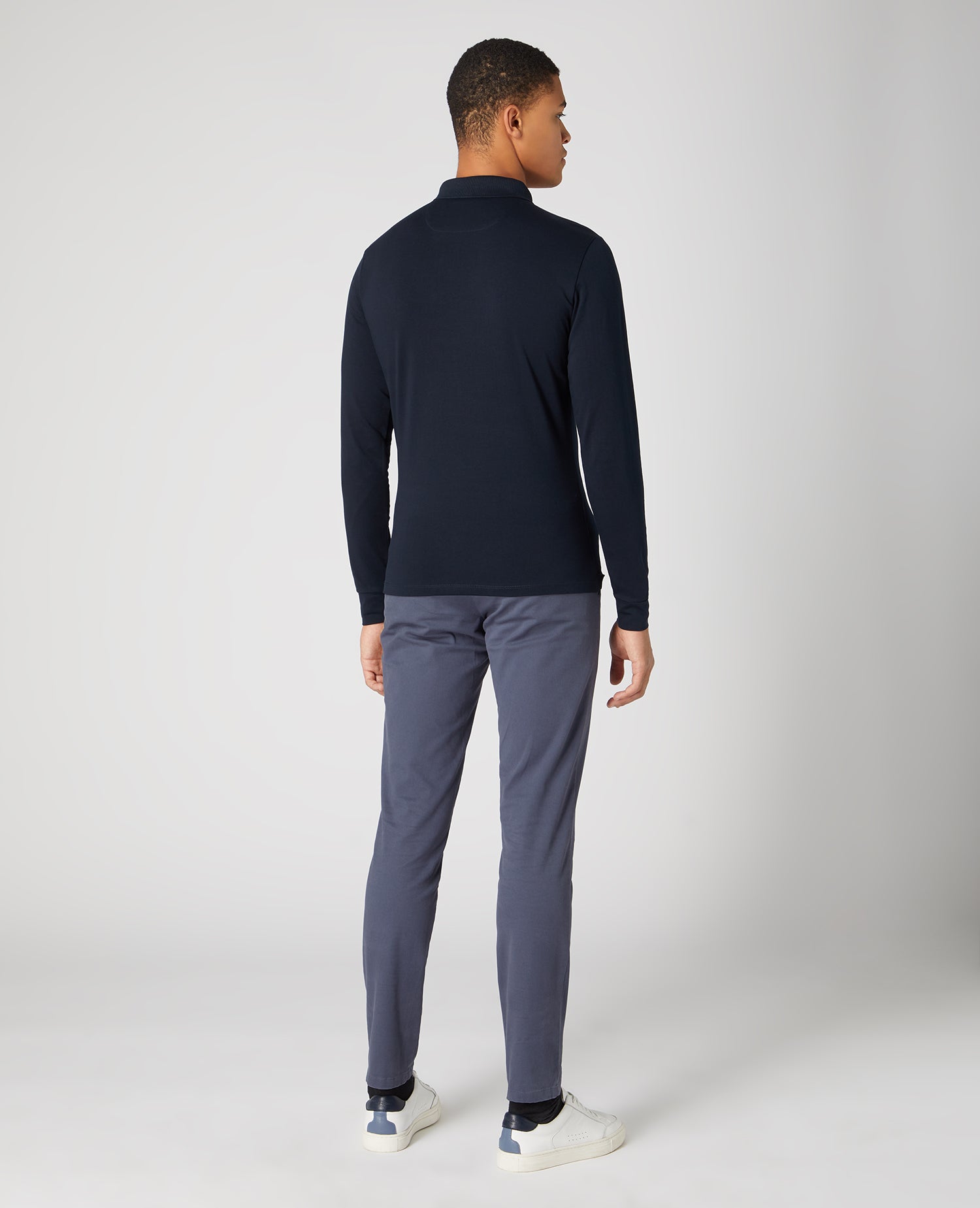 Man wearing a navy Tapered Fit Cotton-Stretch Long-Sleeve Polo Shirt