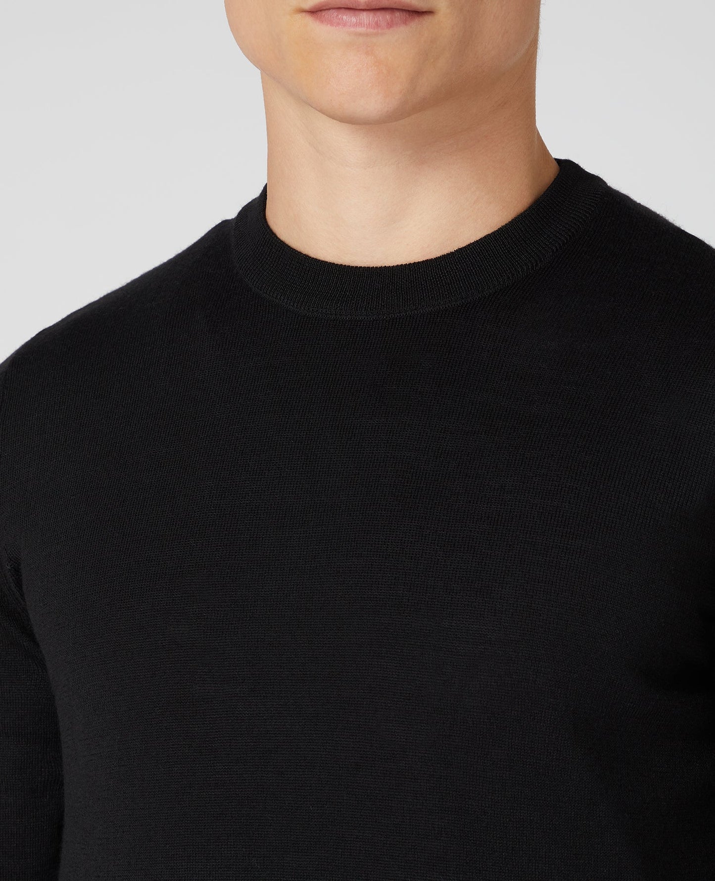 Man wearing a black Tapered Fit Merino Wool-Blend Crew Neck Sweater