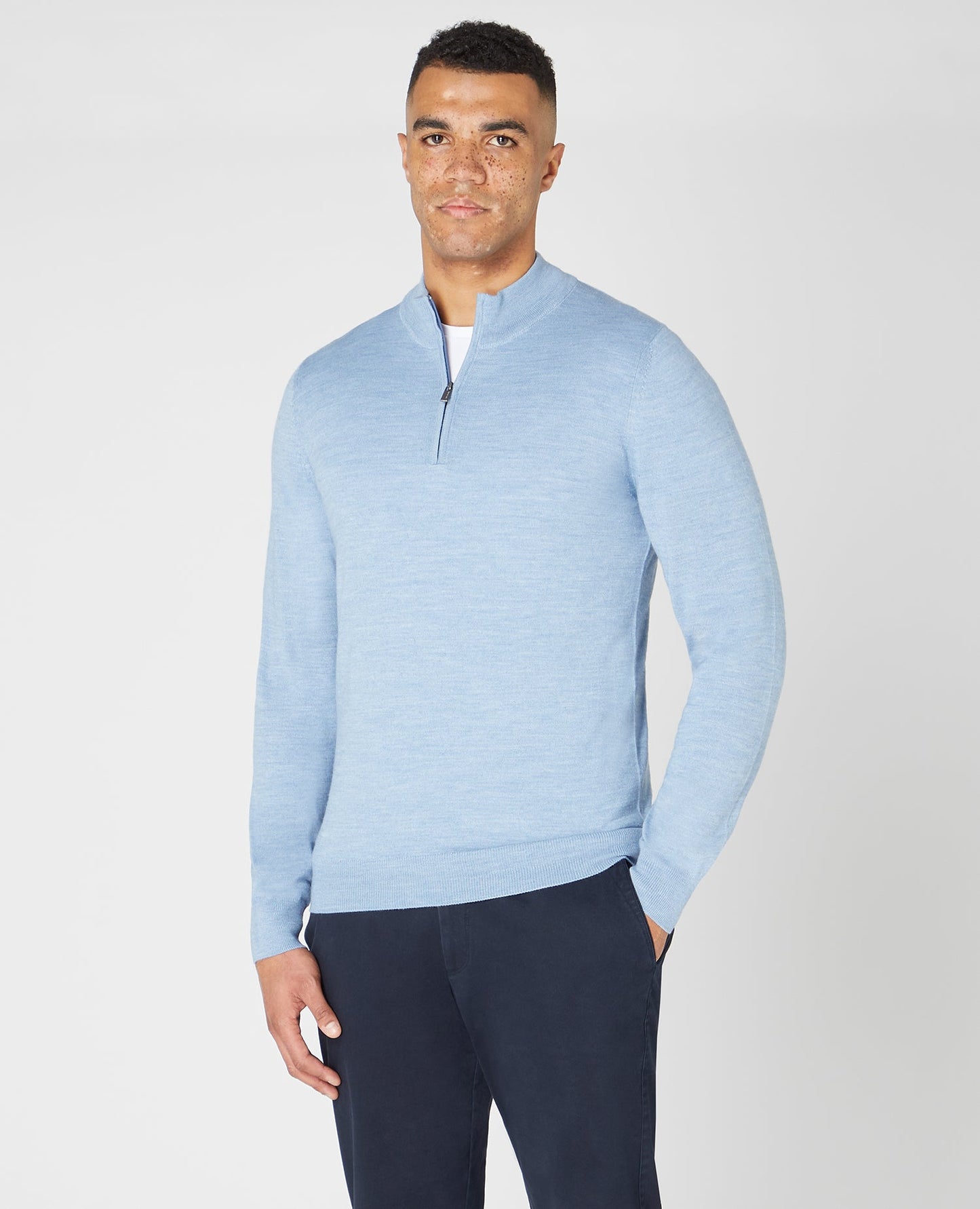 Man wearing a blue Tapered fit Merino Wool Half Zip Sweater