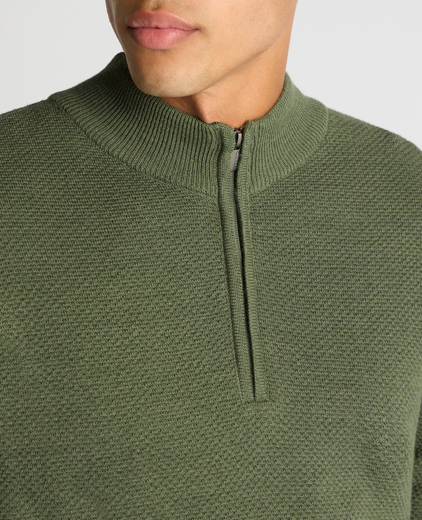 Man wearing a green Tapered Fit Merino Half Zip Sweater