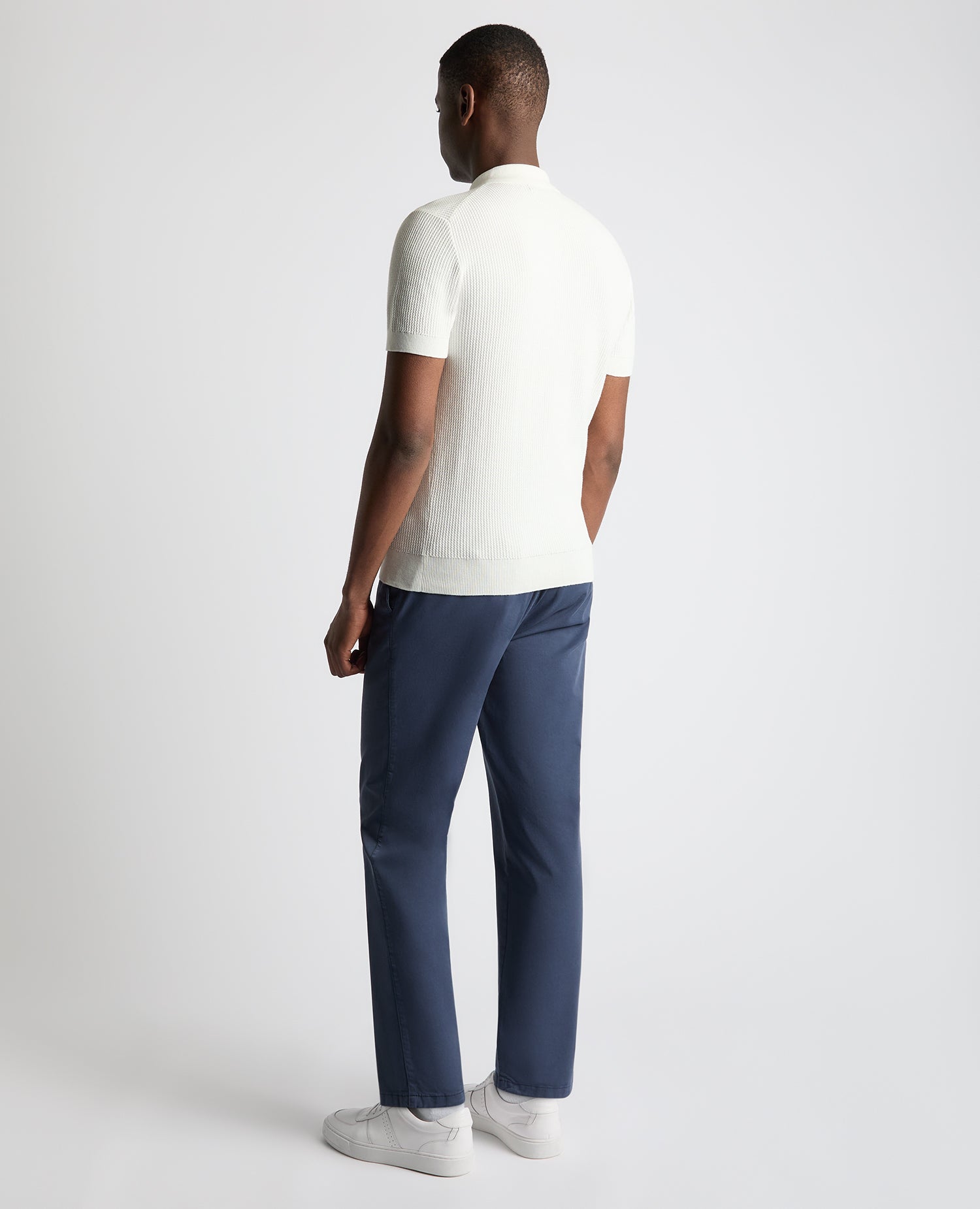 Man wearing a white Slim Fit Cotton Interest Fabric Polo Shirt