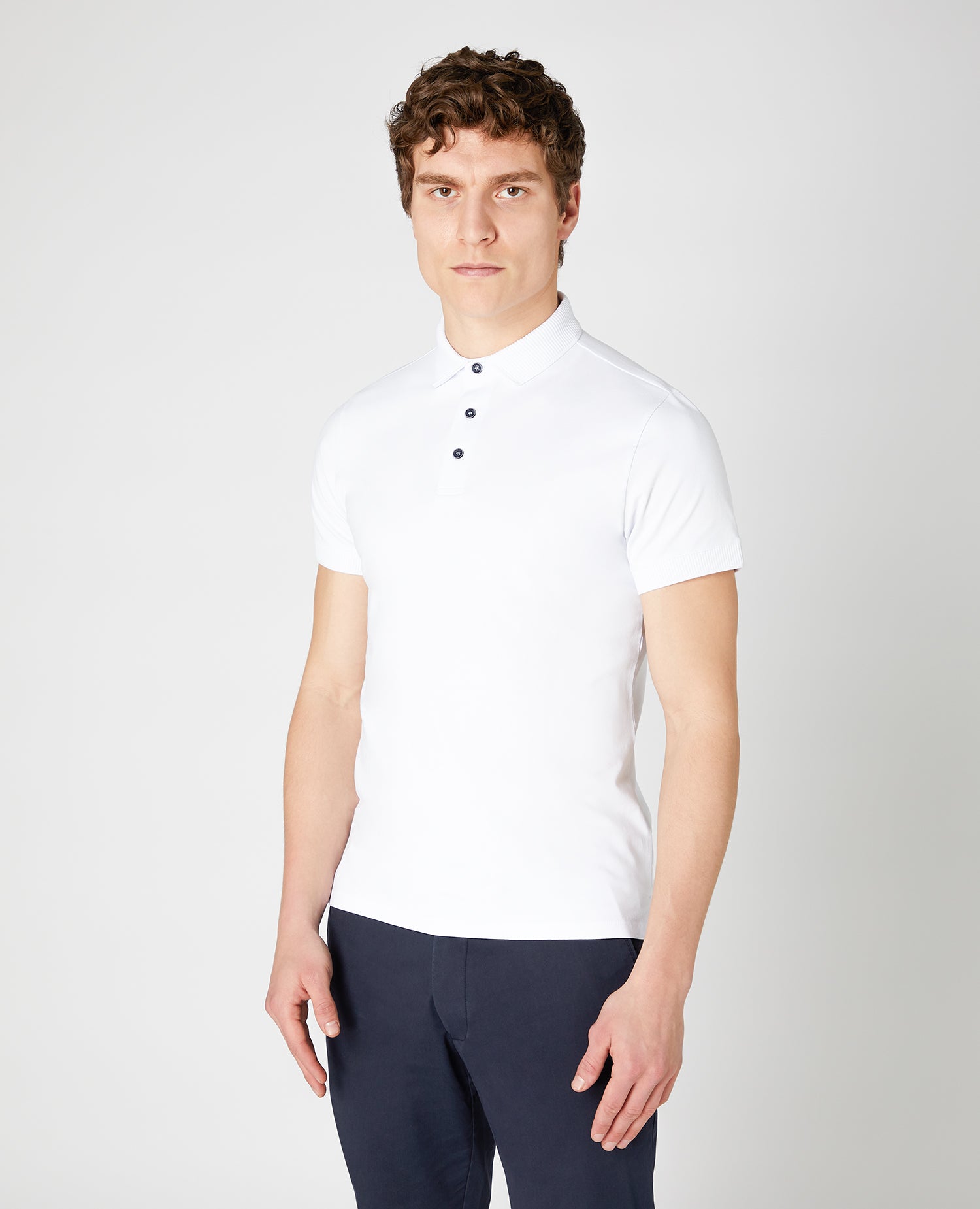 Man wearing a white Tapered Fit Cotton-Stretch Polo Shirt