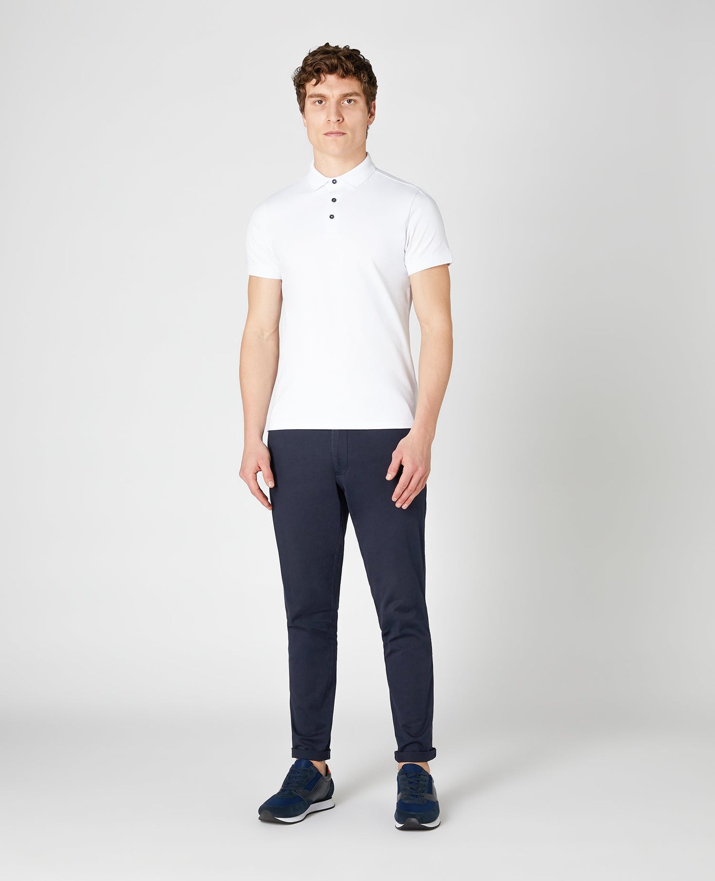 Man wearing a white Tapered Fit Cotton-Stretch Polo Shirt