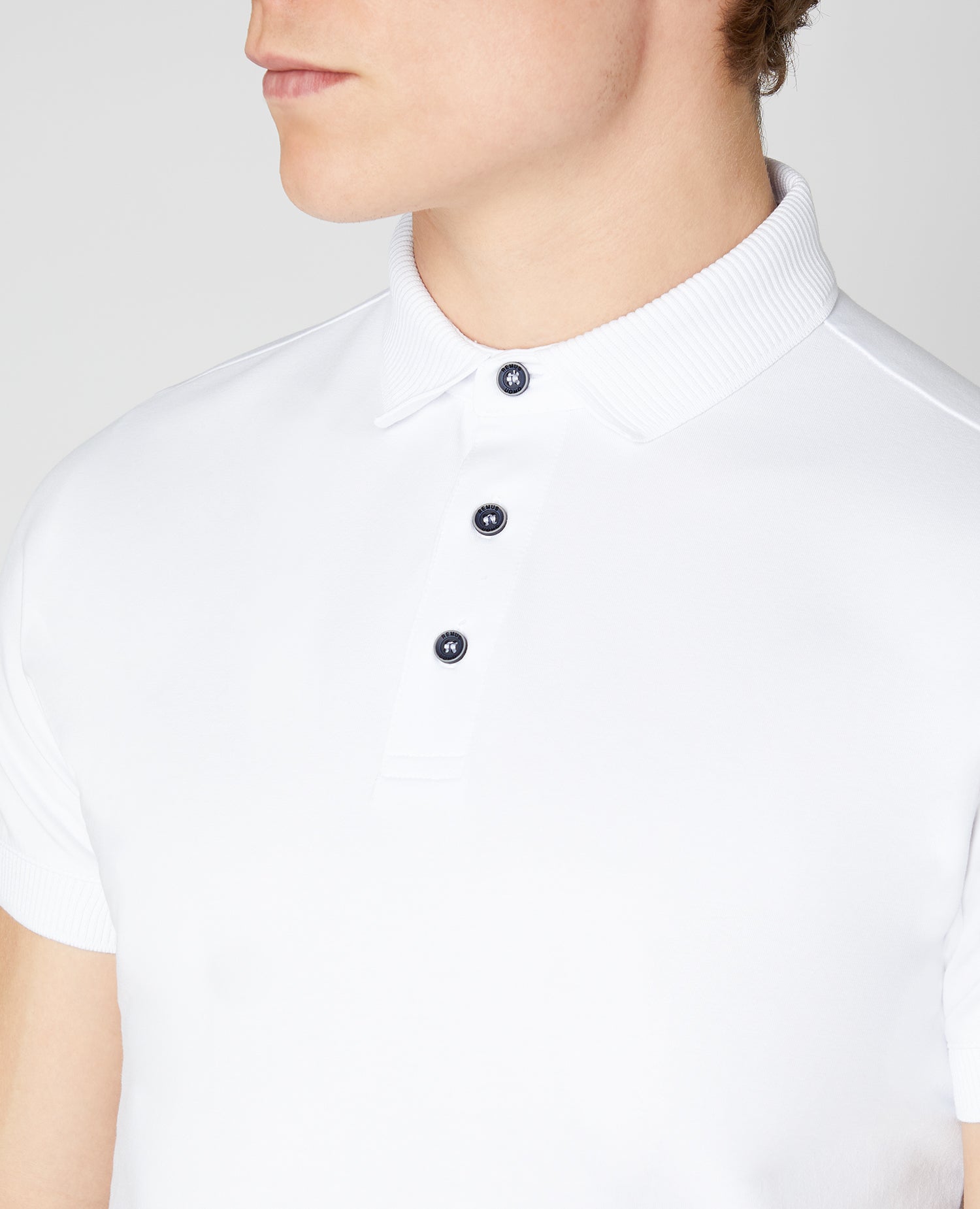 Man wearing a white Tapered Fit Cotton-Stretch Polo Shirt