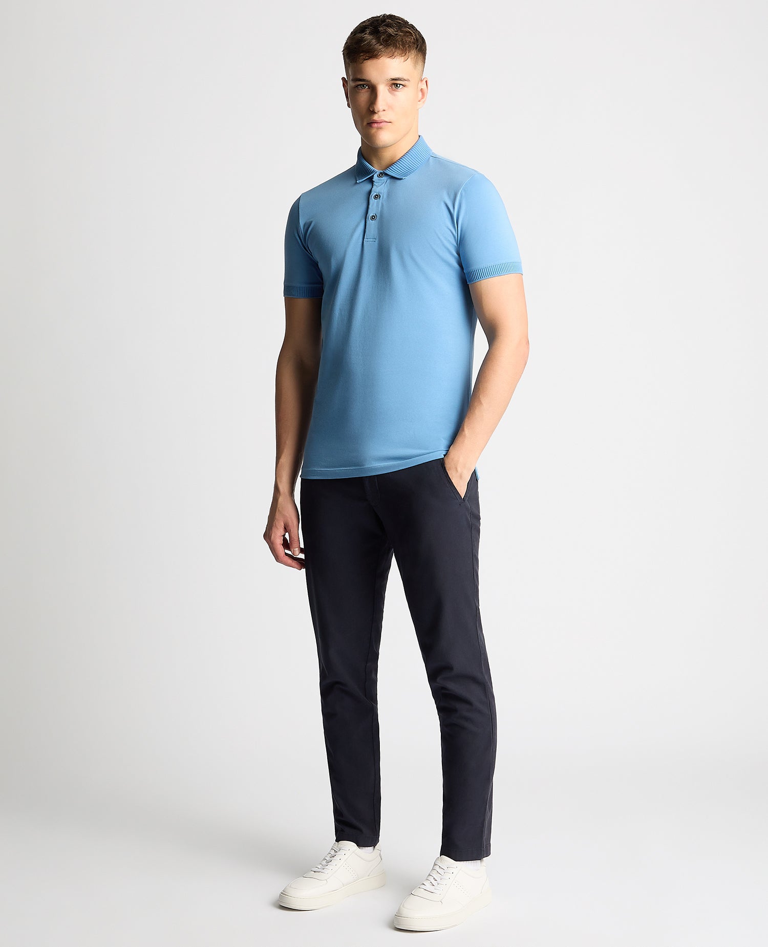 Man wearing a blue Tapered Fit Cotton-Stretch Polo Shirt
