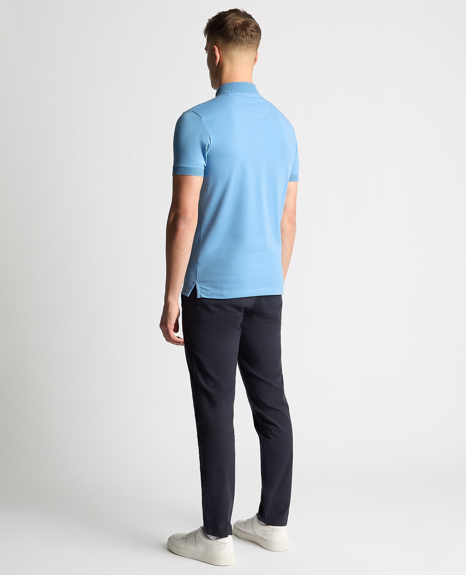 Man wearing a blue Tapered Fit Cotton-Stretch Polo Shirt