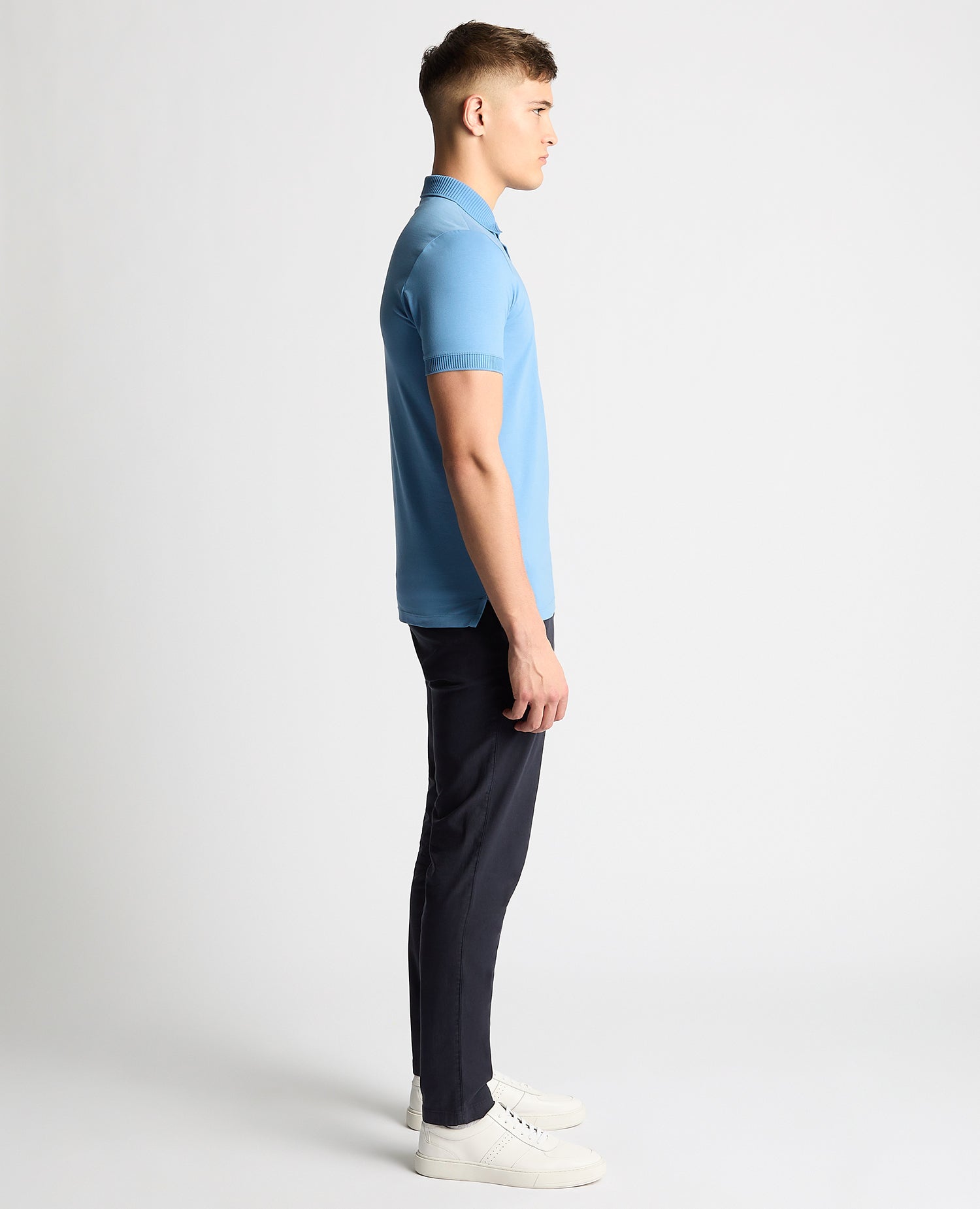 Man wearing a blue Tapered Fit Cotton-Stretch Polo Shirt