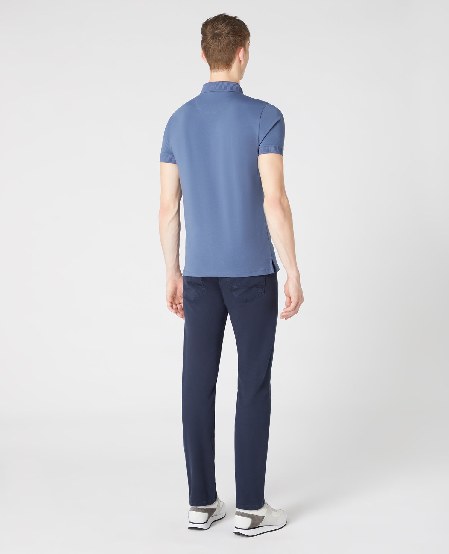 Man wearing a blue Tapered Fit Cotton-Stretch Polo Shirt