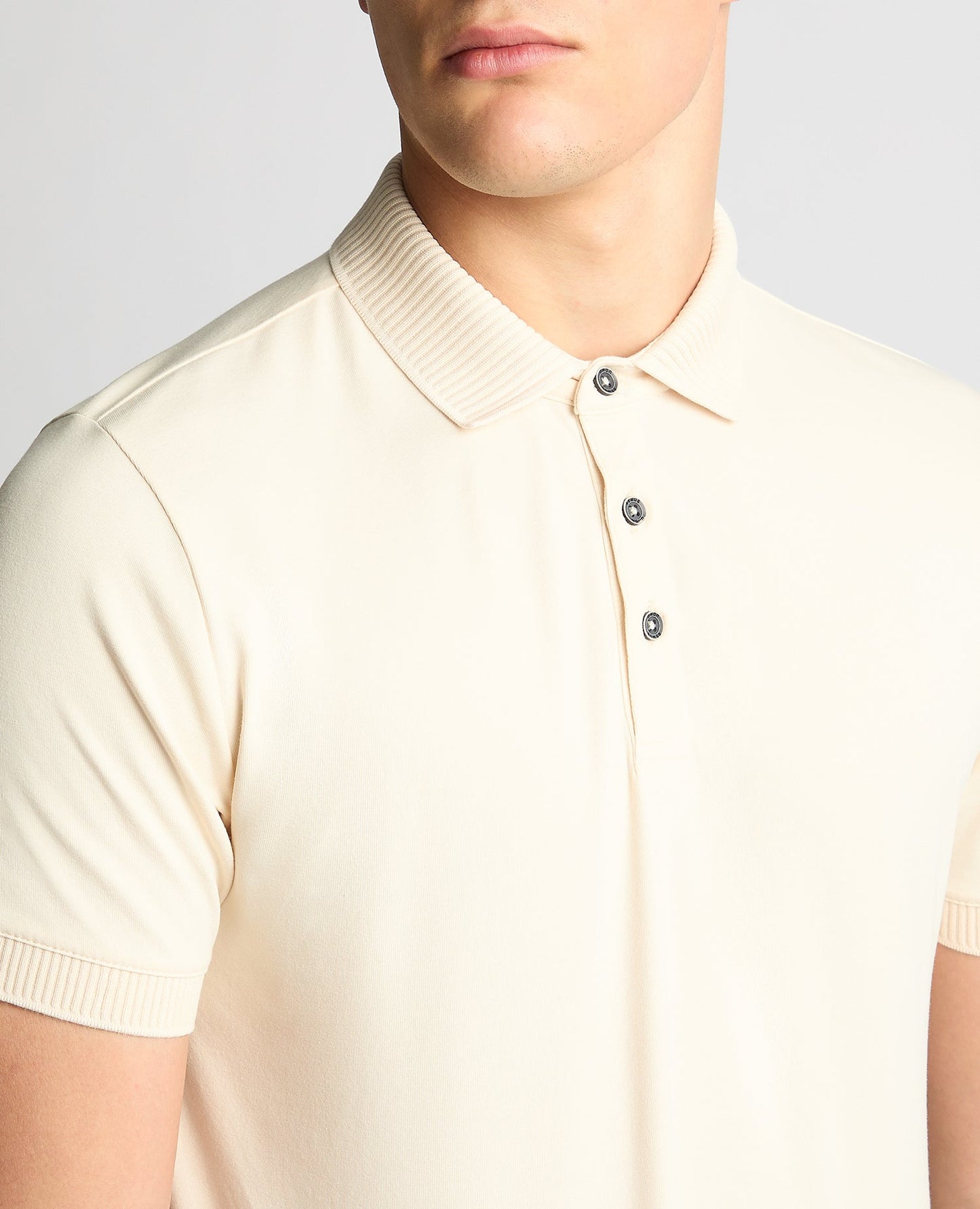 Man wearing a sand Tapered Fit Cotton-Stretch Polo Shirt