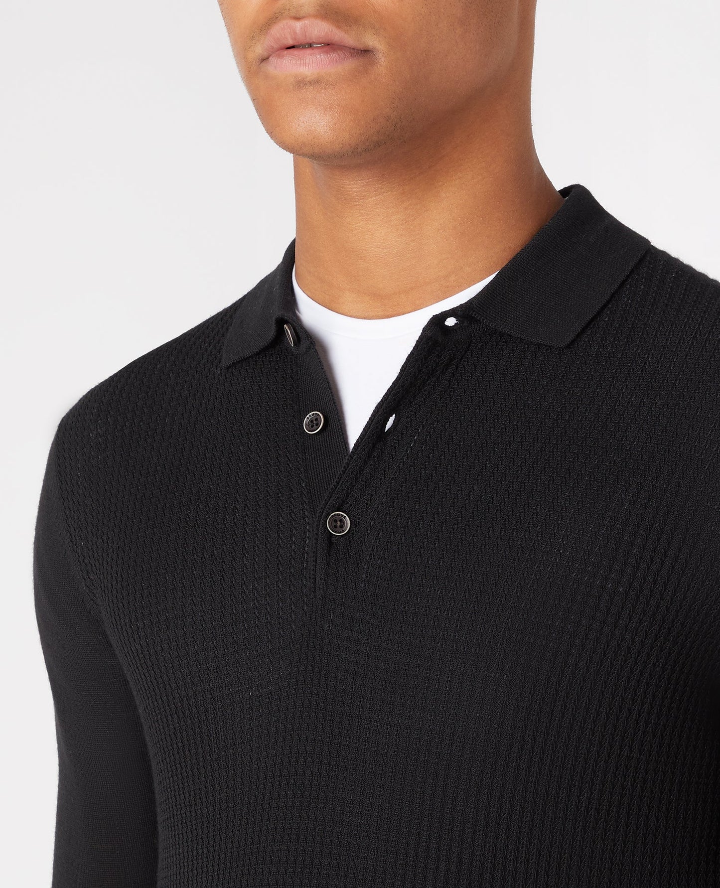 Man wearing a black Slim Fit Merino Wool-Blend Long Sleeve Knitted Polo