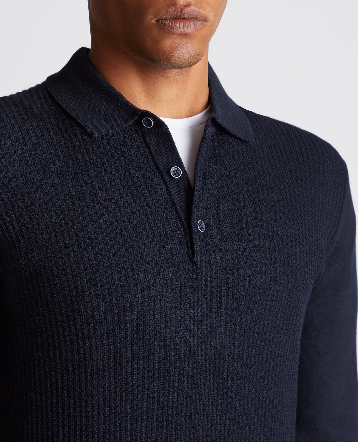 Man wearing a navy Slim Fit Merino Wool-Blend Long Sleeve Knitted Polo