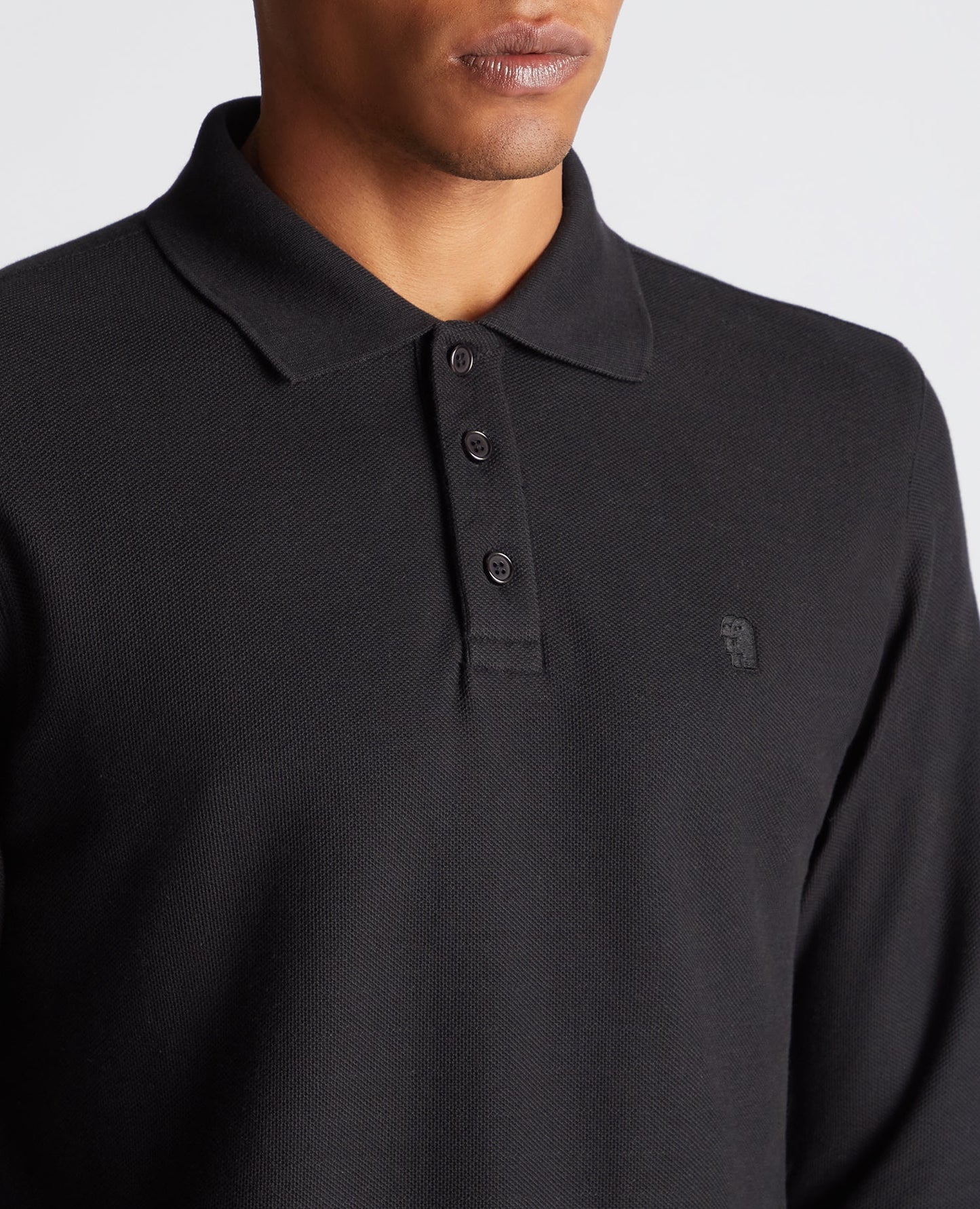 Man wearing a black Slim Fit Cotton-Stretch Pique Polo Shirt