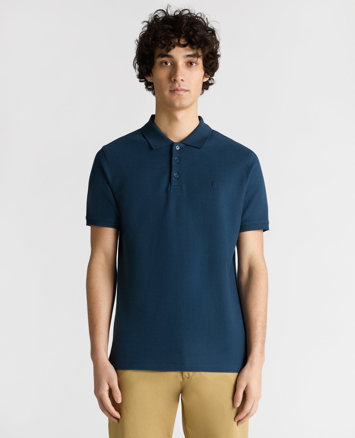Man wearing a blue Tapered Fit Cotton Pique Polo Shirt