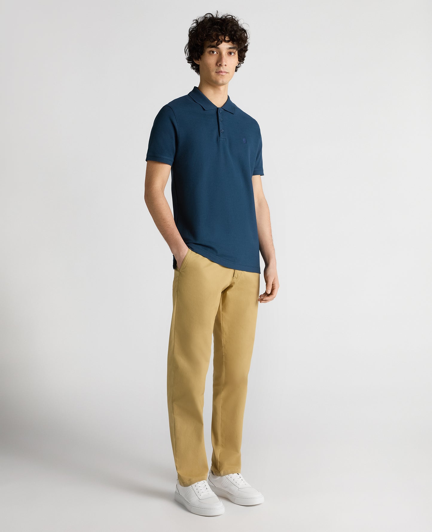 Man wearing a blue Tapered Fit Cotton Pique Polo Shirt