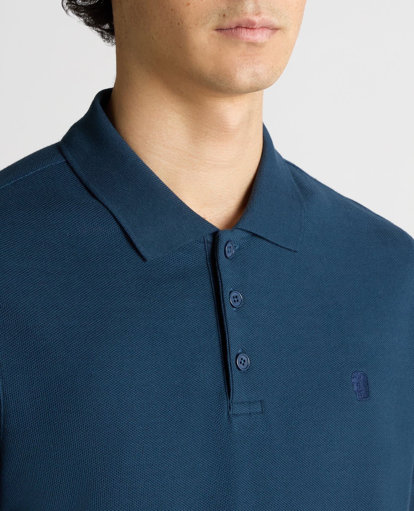 Man wearing a blue Tapered Fit Cotton Pique Polo Shirt