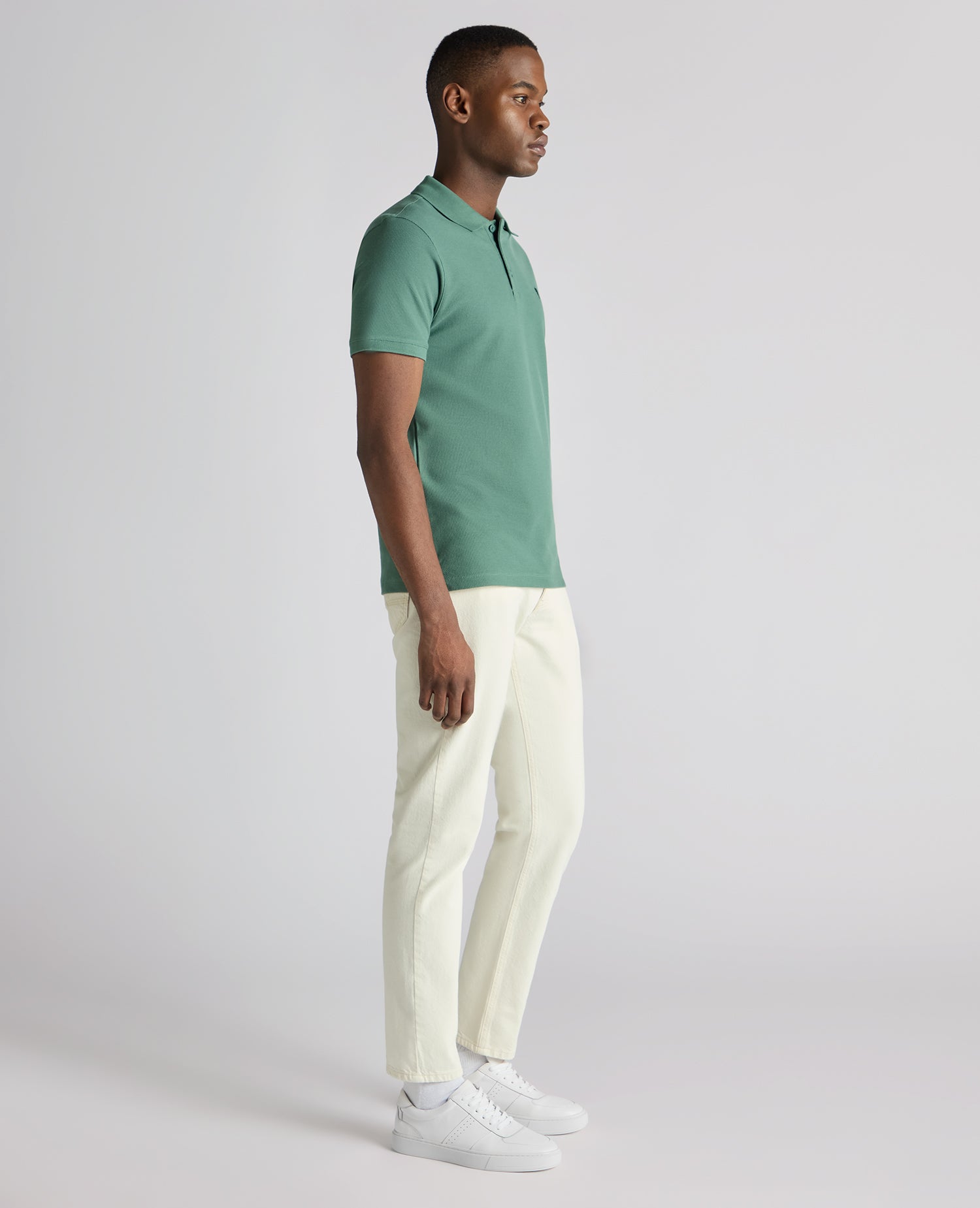 Man wearing a green Tapered Fit Cotton Pique Polo Shirt