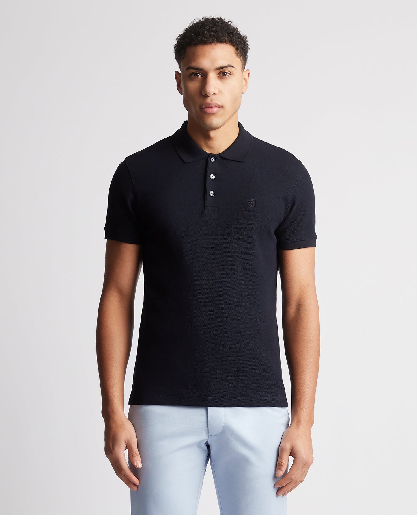 Man wearing a navy Tapered Fit Cotton Pique Polo Shirt