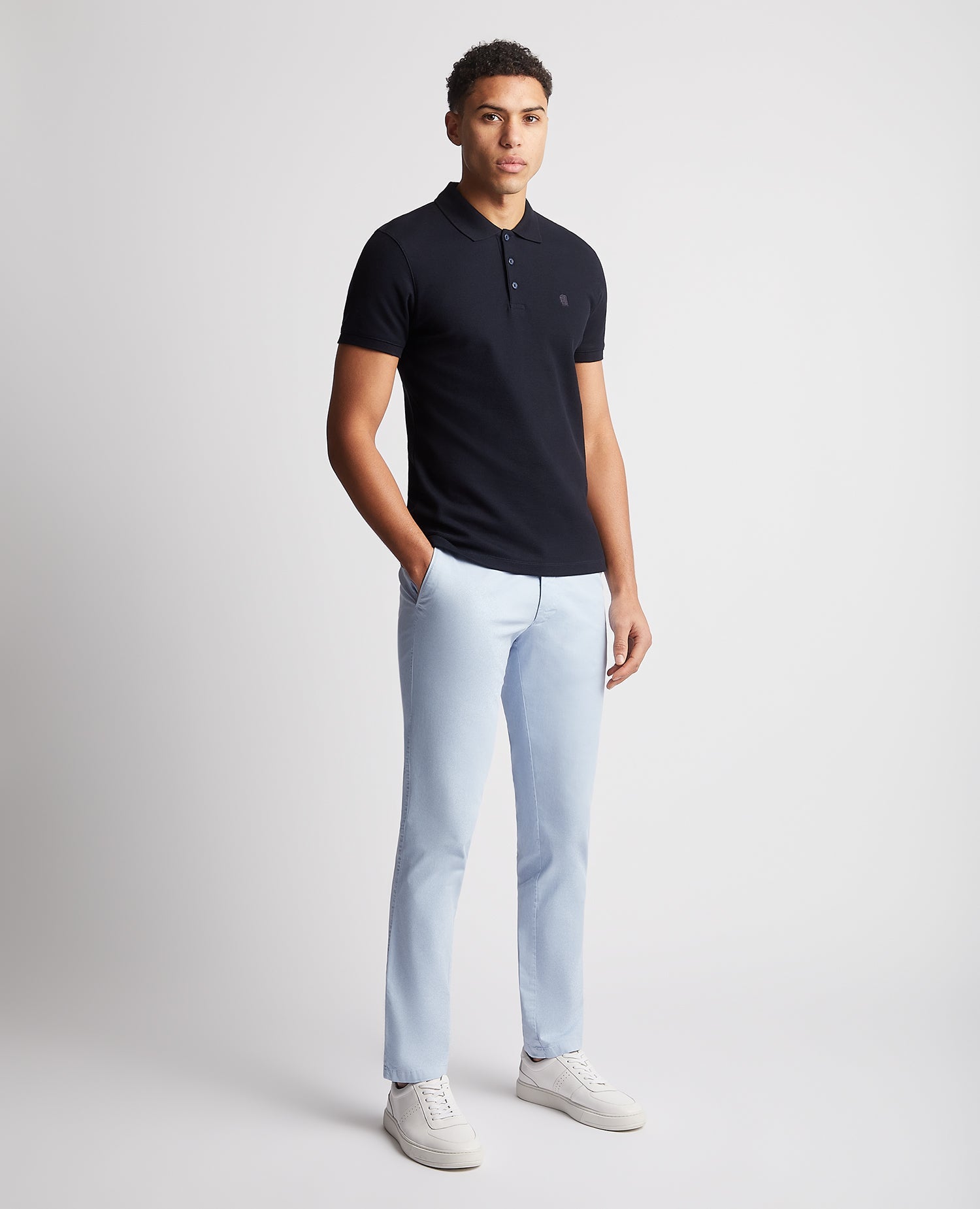 Man wearing a navy Tapered Fit Cotton Pique Polo Shirt