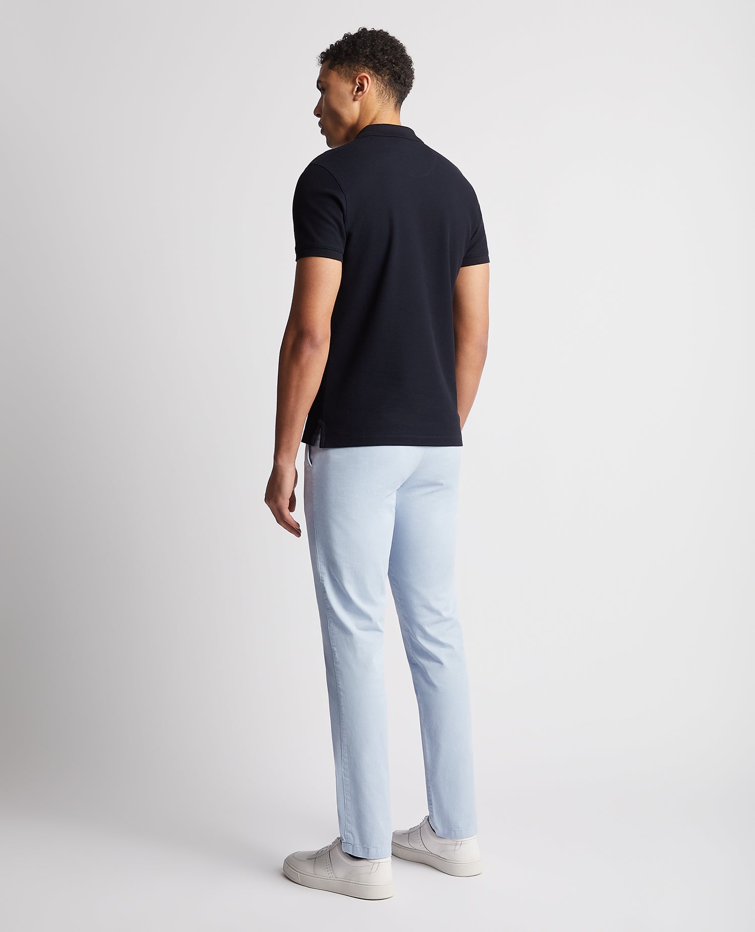 Man wearing a navy Tapered Fit Cotton Pique Polo Shirt