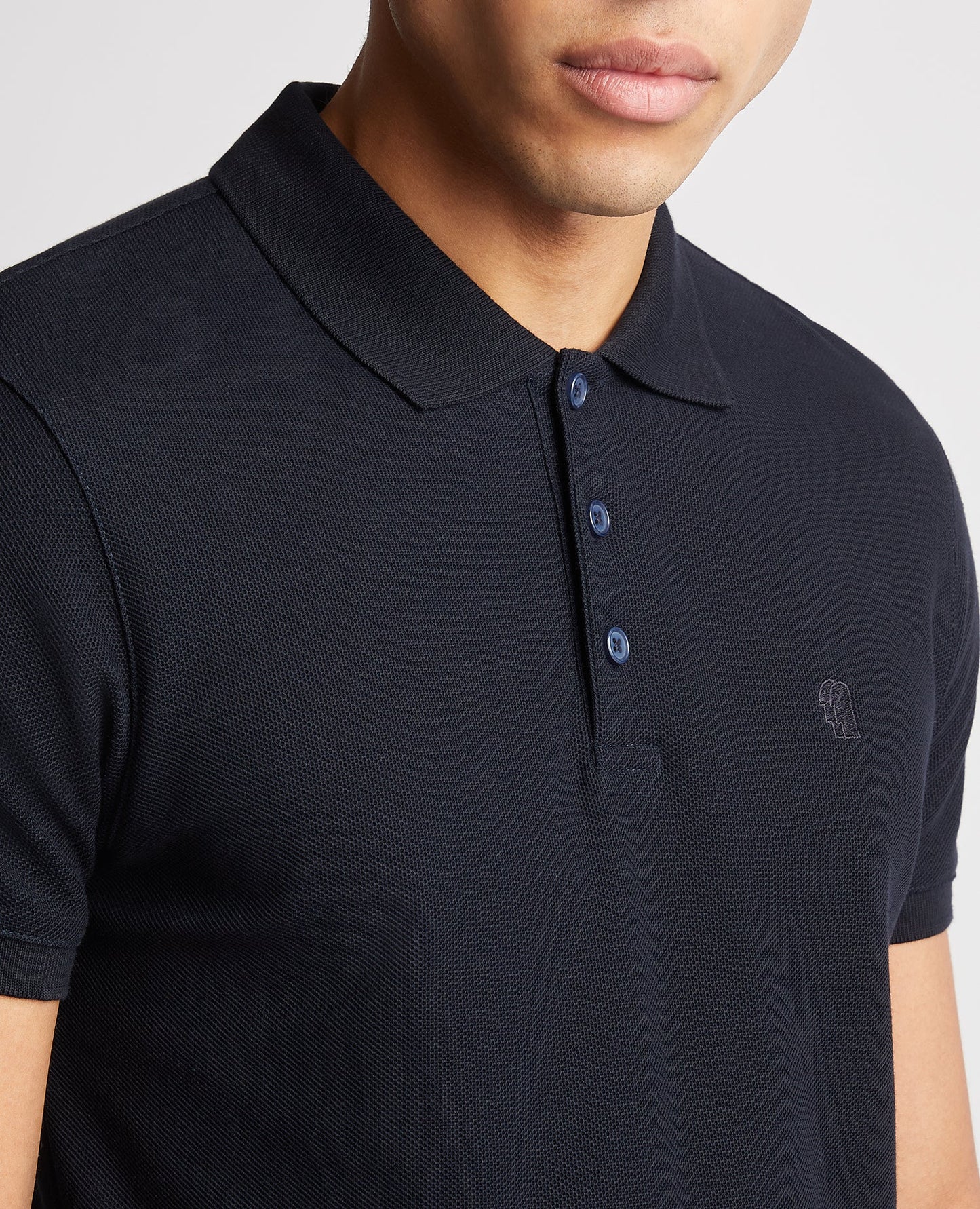 Man wearing a navy Tapered Fit Cotton Pique Polo Shirt