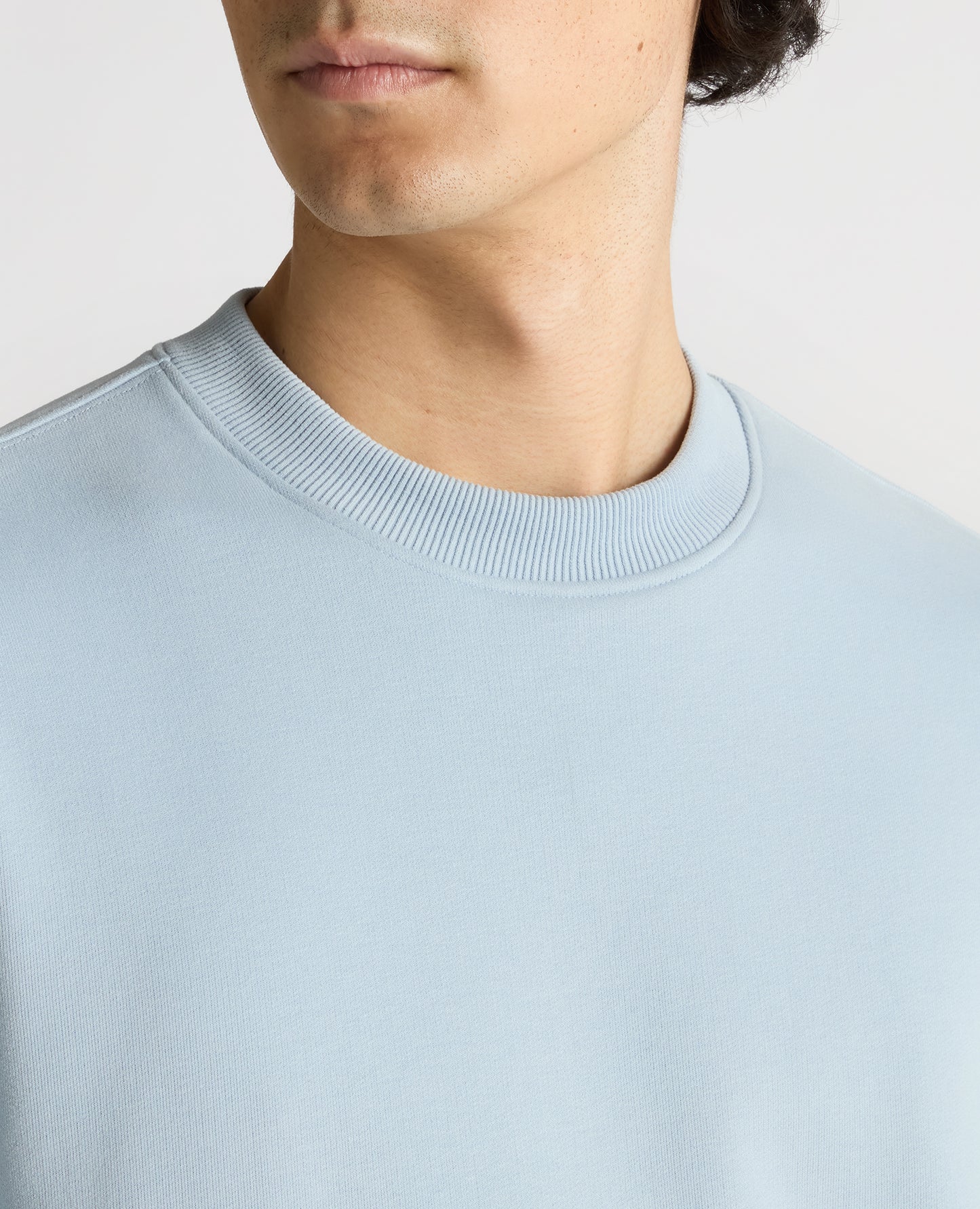 Man wearing a blue Tapered Fit Soft Touch Cotton-Blend Sweatshirt