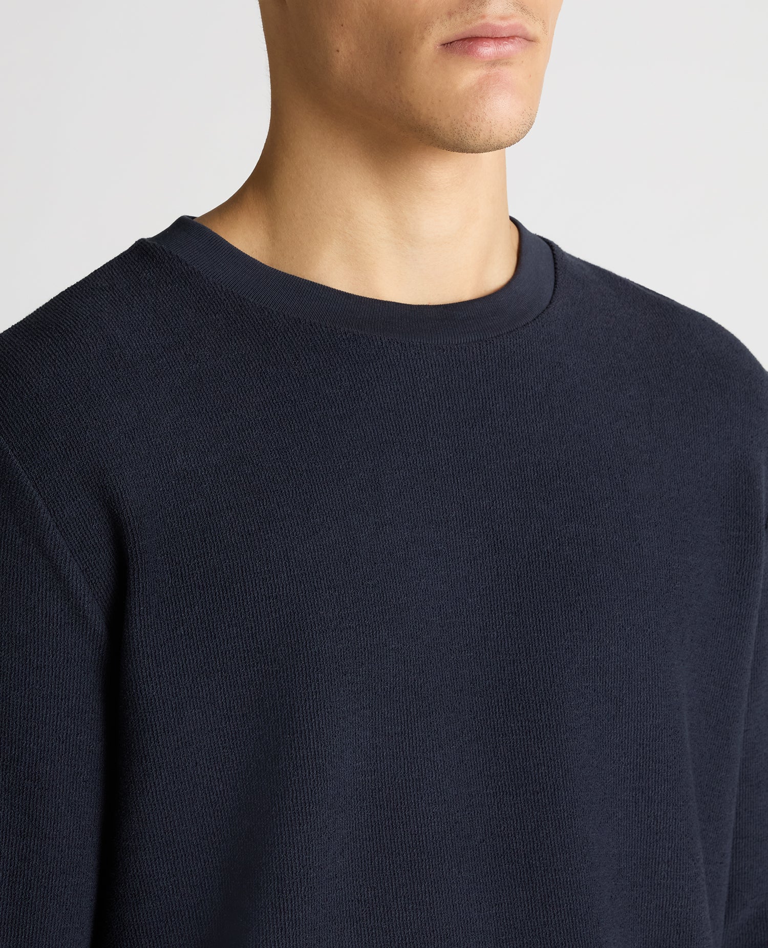 Man wearing a navy Tapered Fit Cotton Micro Waffle Sweatshirt