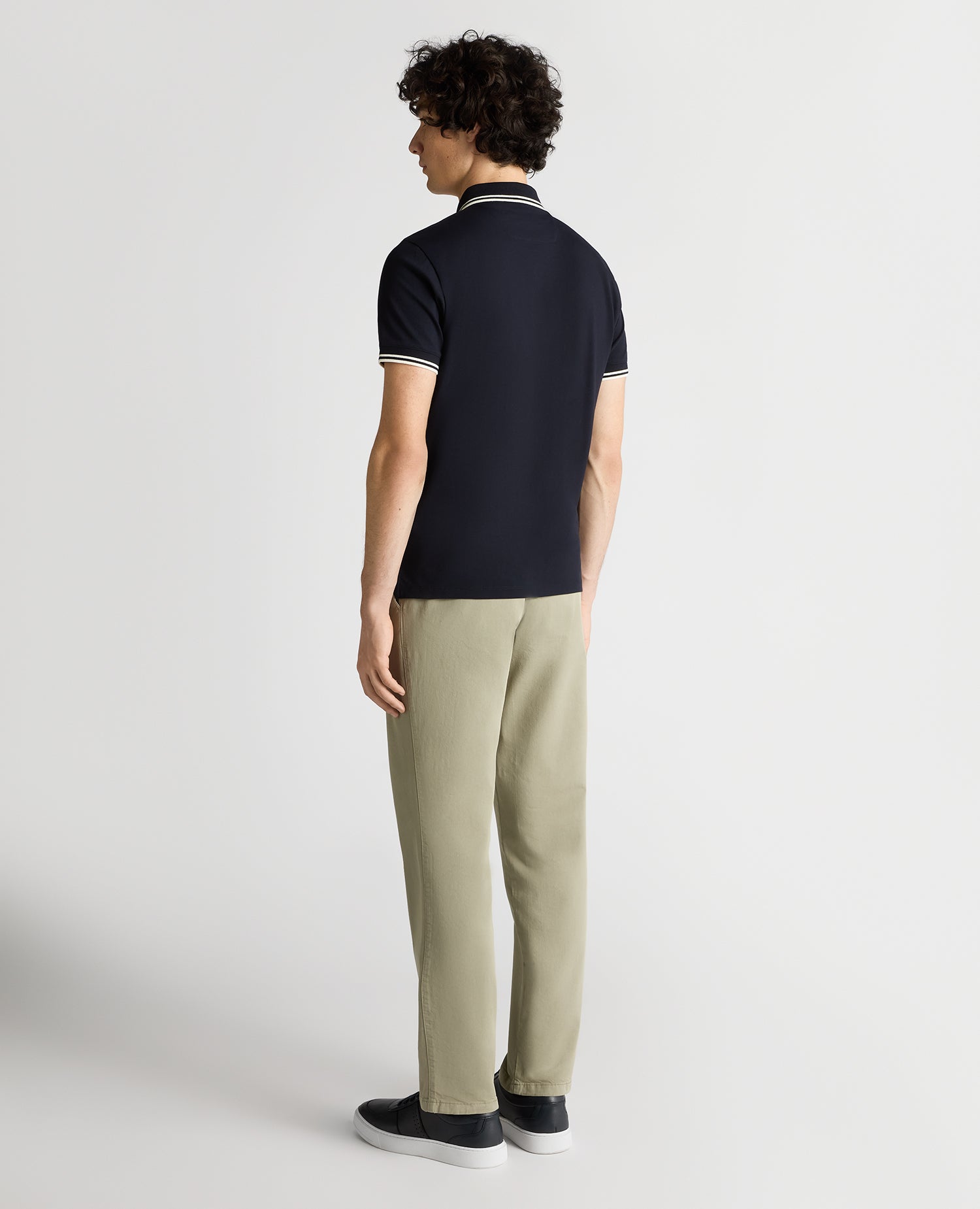 Man wearing a navy Tapered Fit Cotton-Stretch Polo Shirt