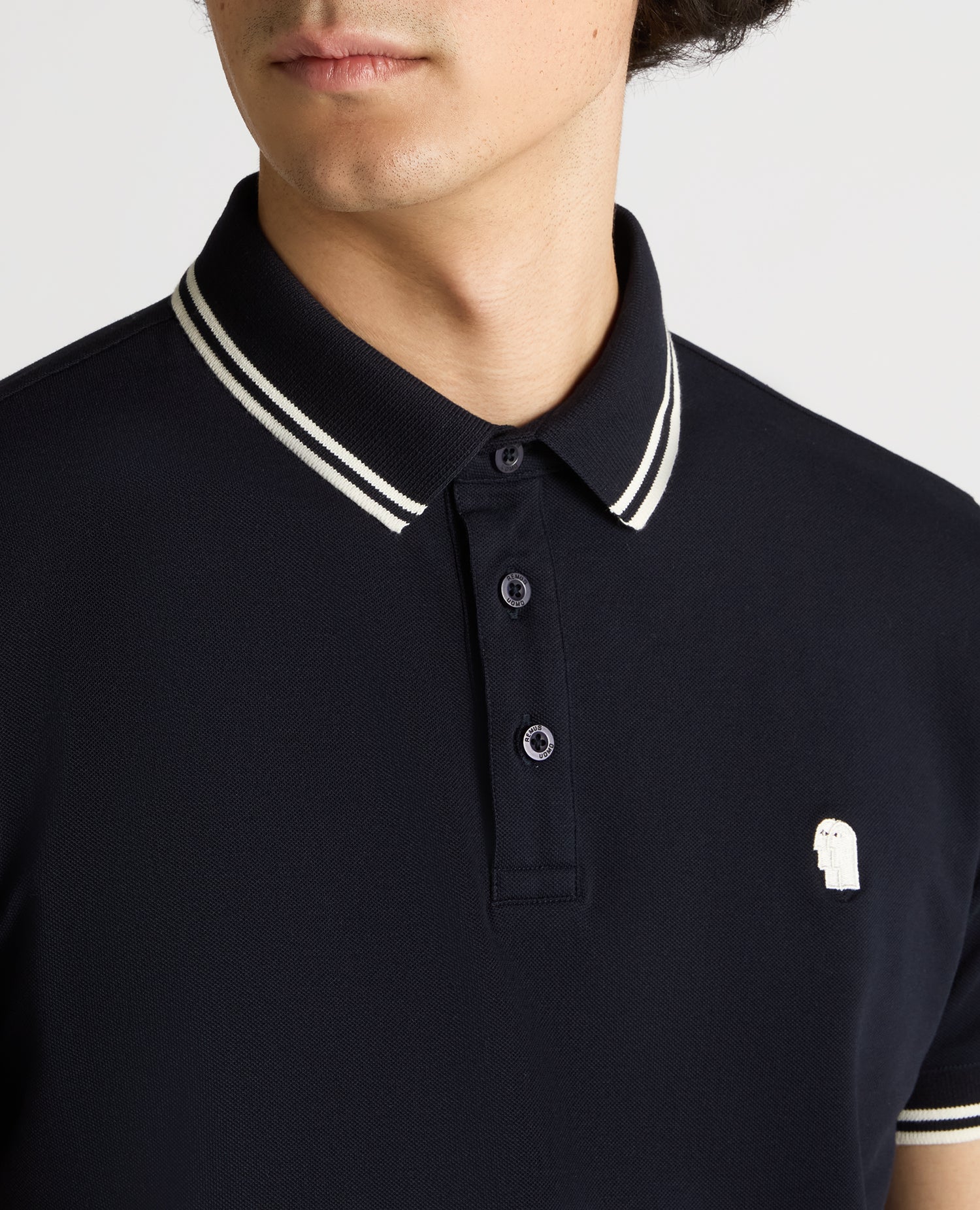 Man wearing a navy Tapered Fit Cotton-Stretch Polo Shirt