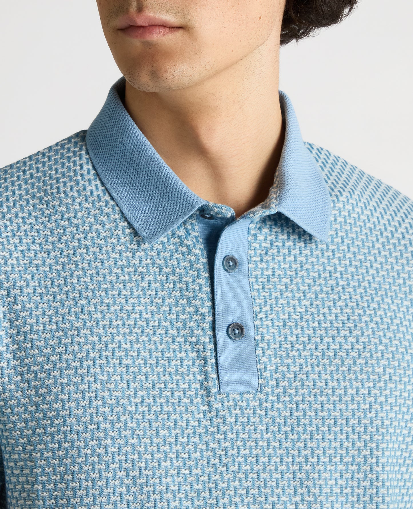 Man wearing a blue Tapered Fit Basket Weave Polo Shirt