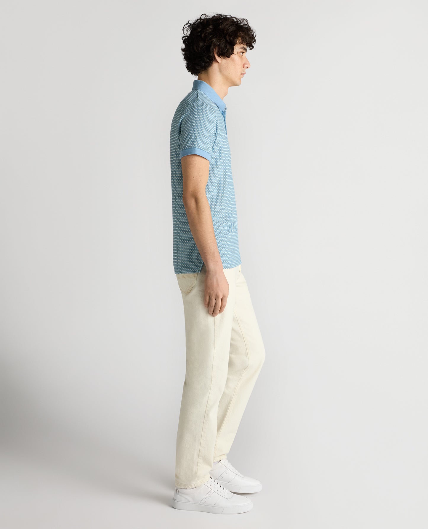 Man wearing a blue Tapered Fit Basket Weave Polo Shirt