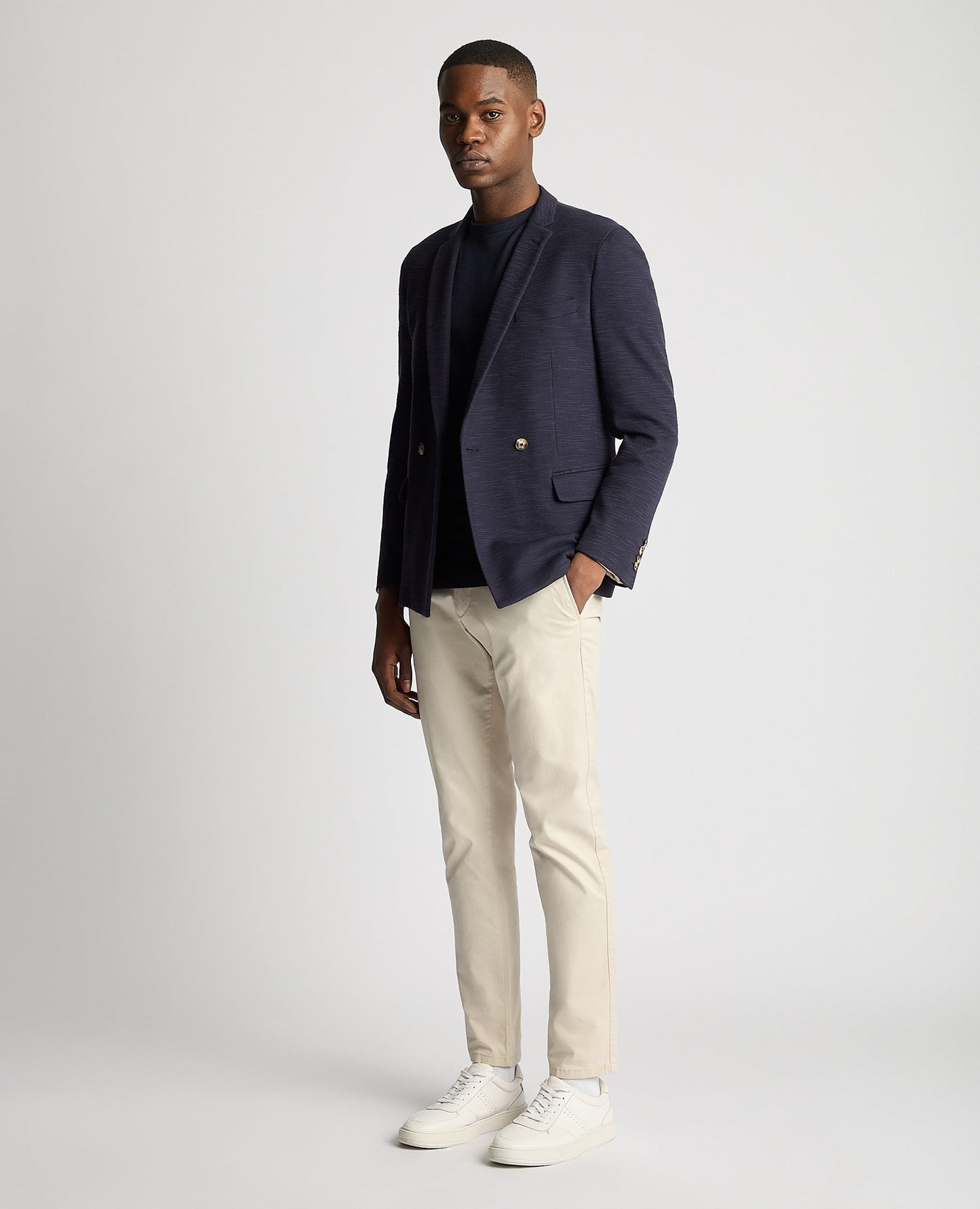 Man wearing a navy Slim Fit Cotton-Stretch Double Breasted Jacket